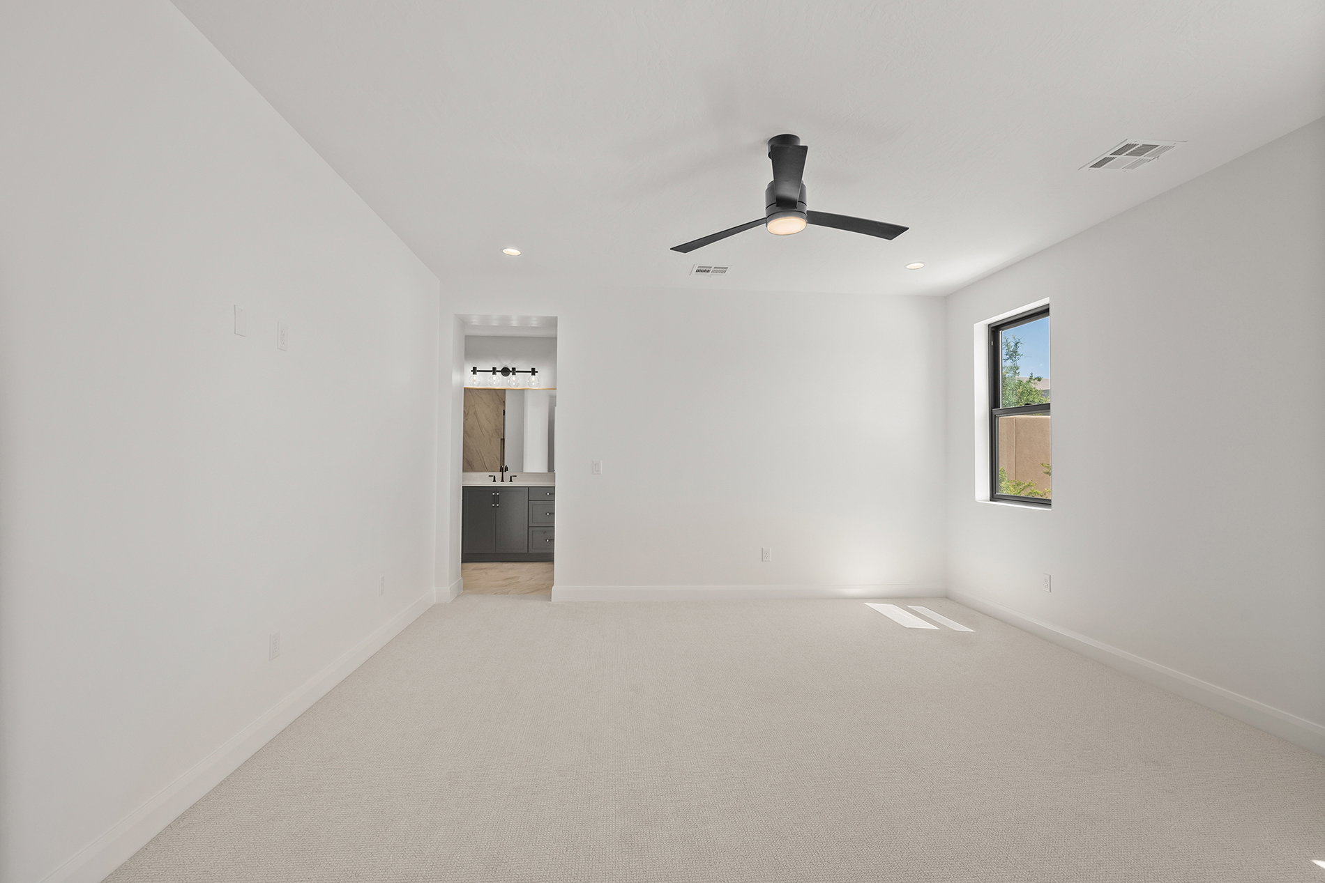Spacious room with light-toned carpeting and white walls