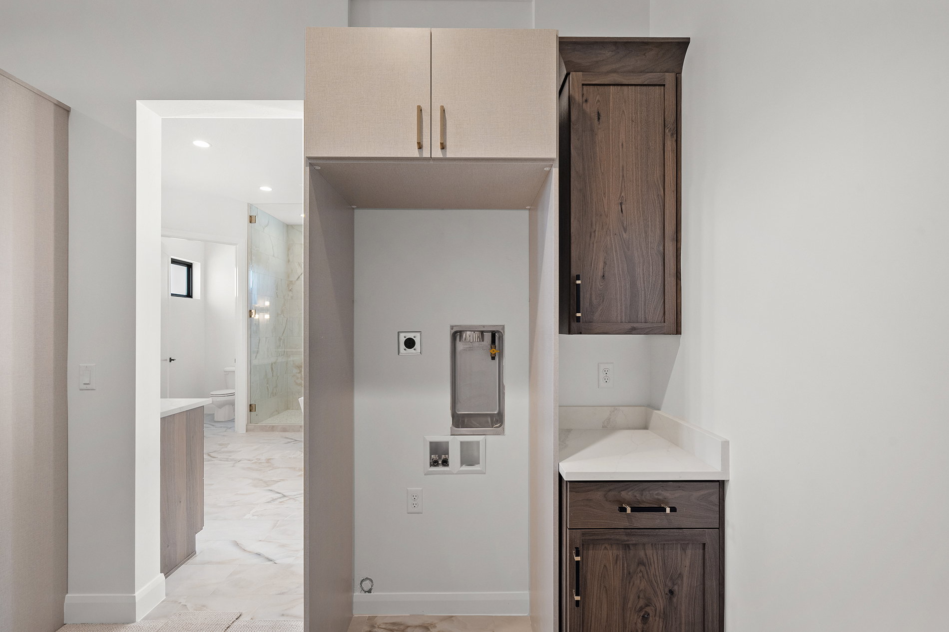 Dedicated laundry area featuring upper and lower cabinetry, a spacious countertop, and hookups for appliances