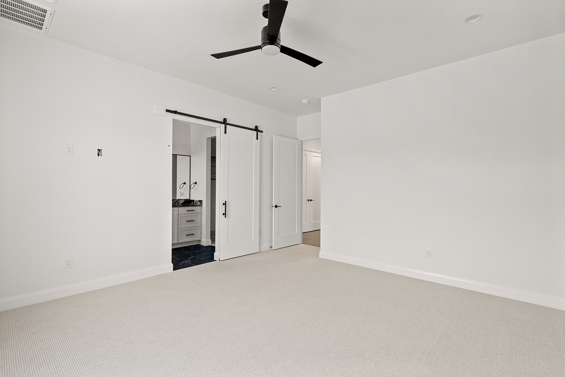 Spacious room featuring light-toned carpet flooring and white painted walls