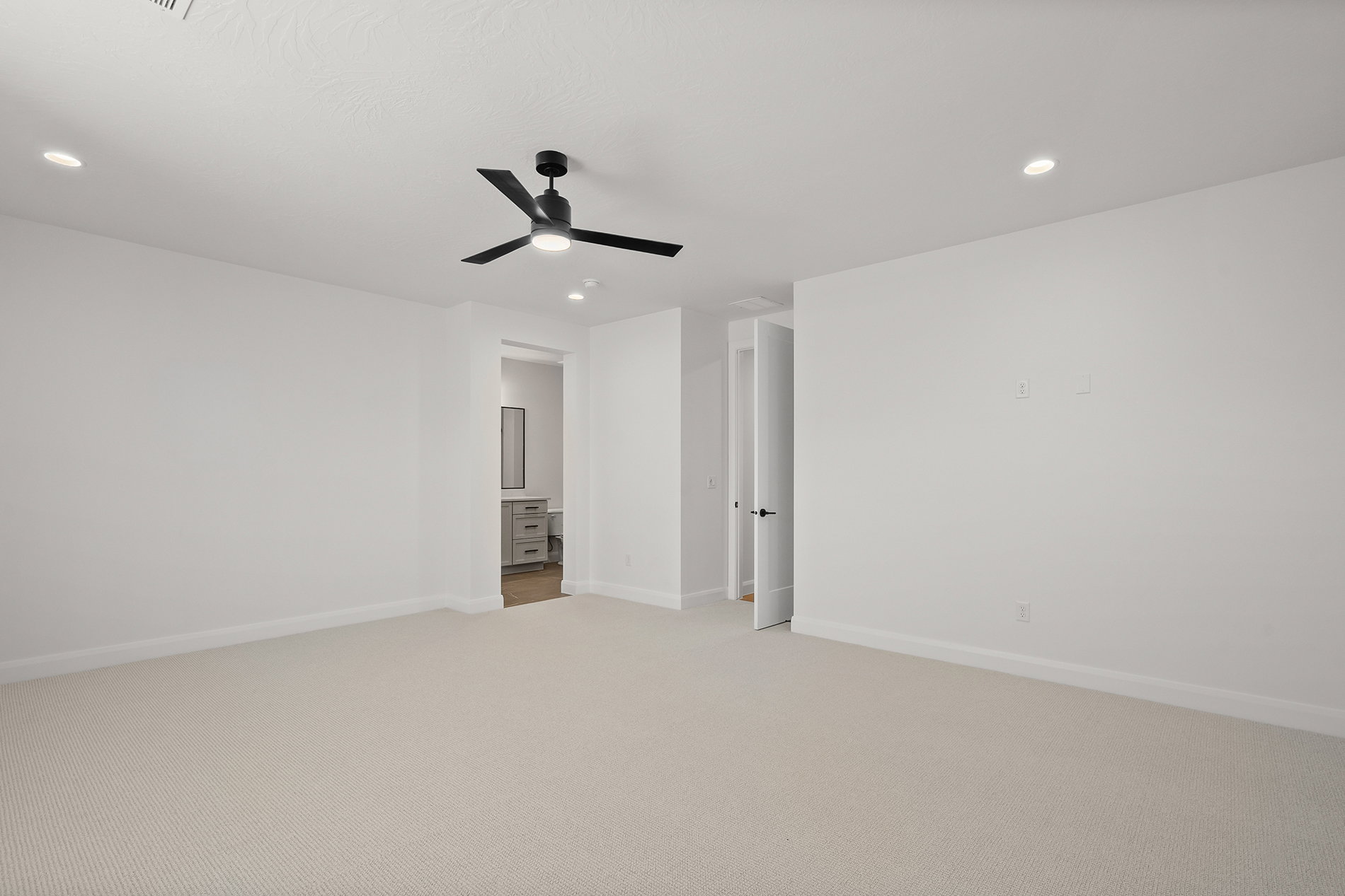 Spacious room featuring neutral carpeting, a modern ceiling fan with integrated lighting, and recessed ceiling lights