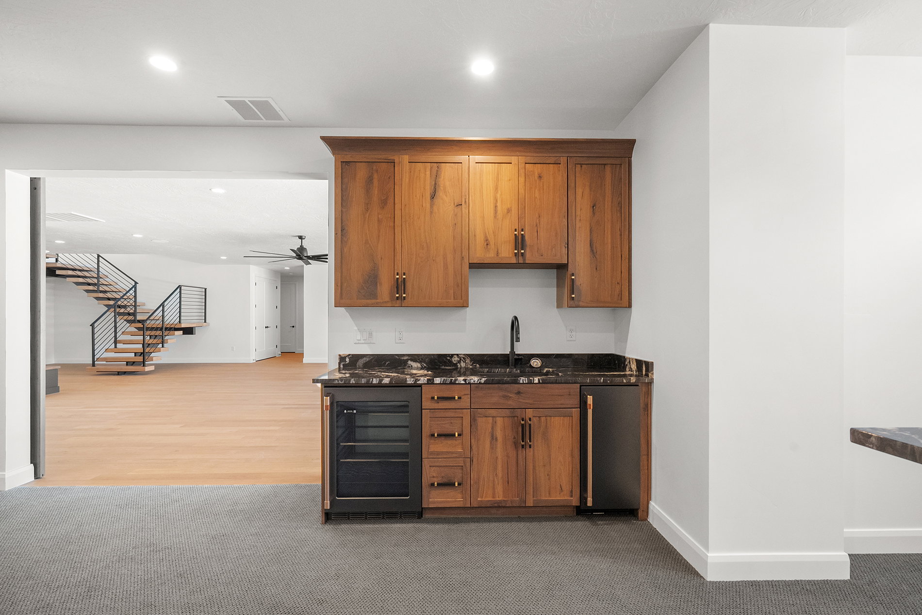 Custom wet bar featuring wood cabinetry, dark countertop, and integrated beverage refrigerator