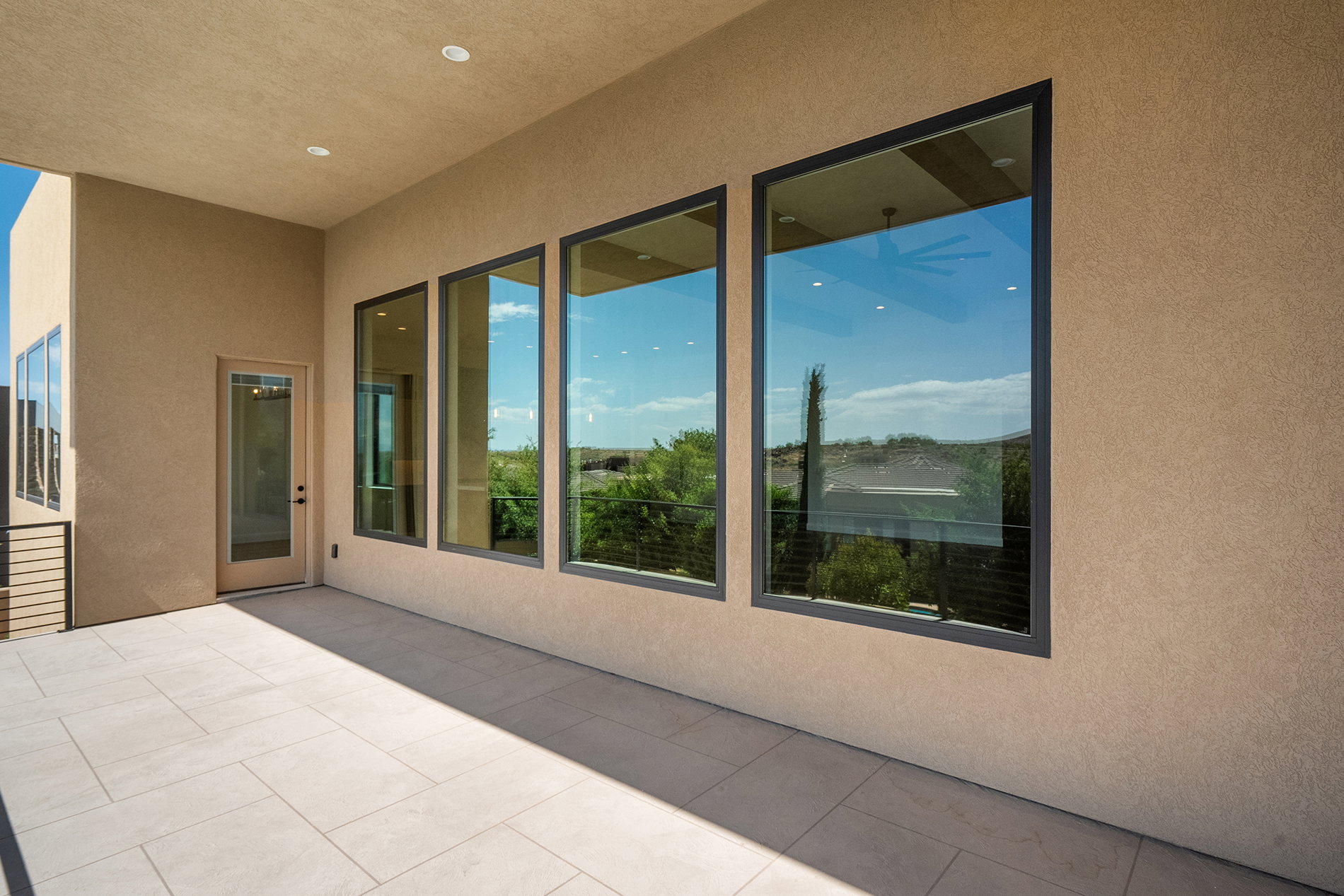 Covered outdoor patio featuring light-toned large format tile flooring and stucco exterior