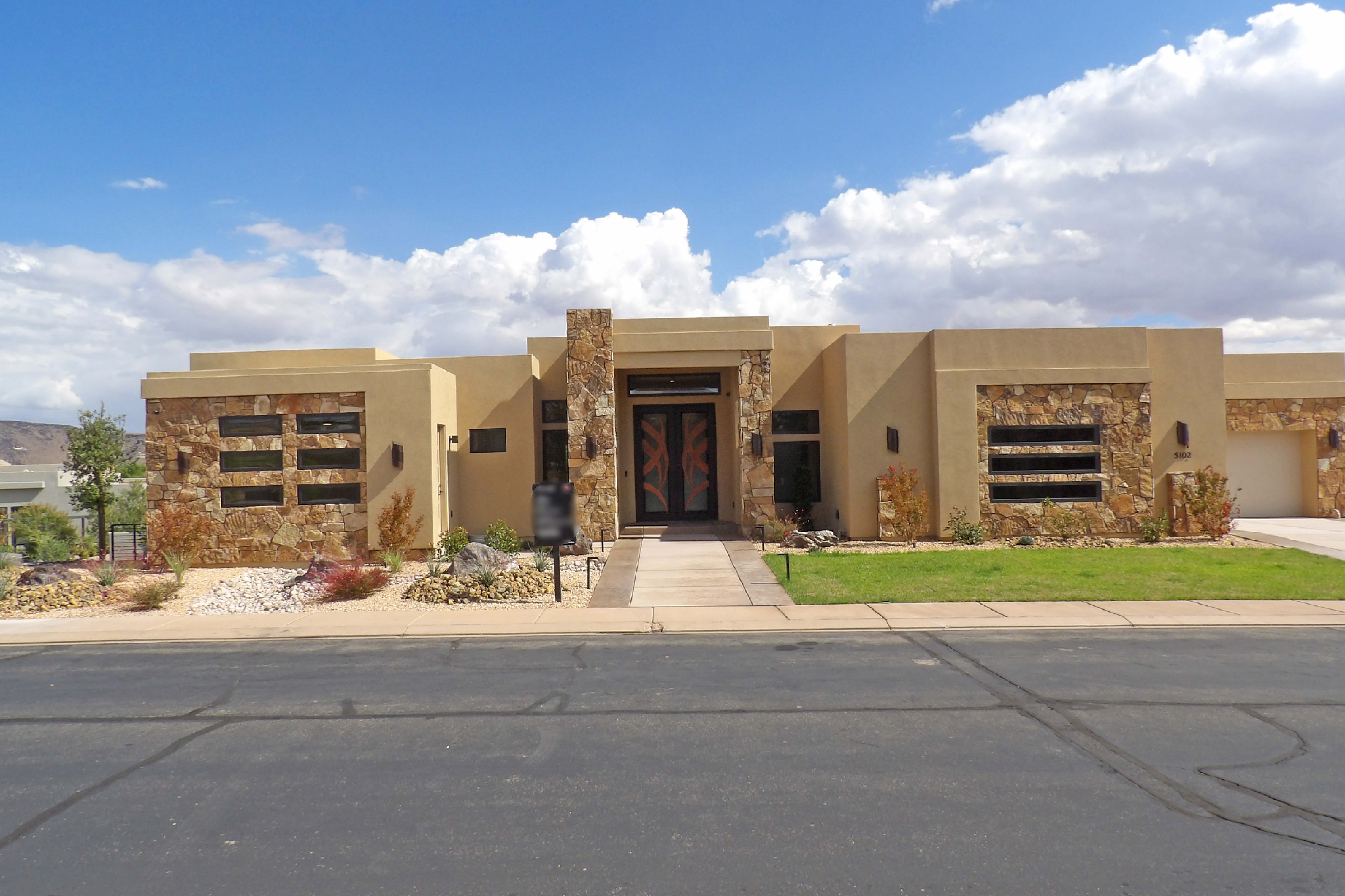 Contemporary stucco residence featuring stone accents and a flat roofline
