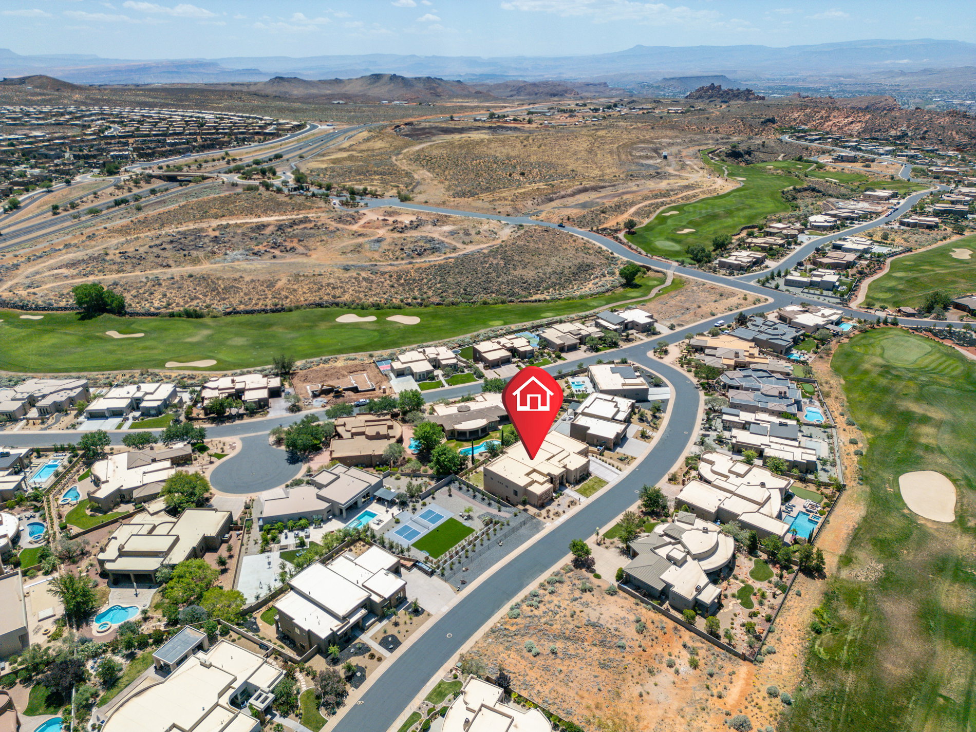 Aerial view of a residential community featuring diverse architectural styles, integrated golf course, and desert landscaping
