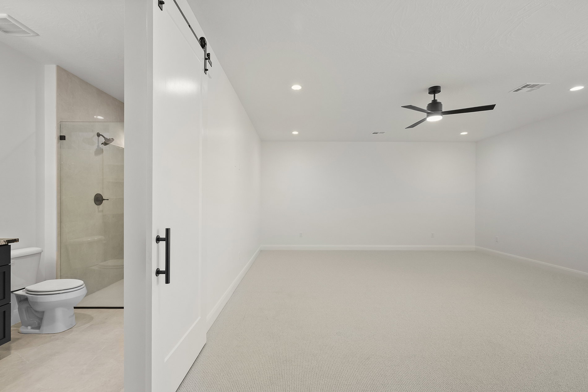 Spacious carpeted room featuring a ceiling fan with integrated lighting and recessed lighting