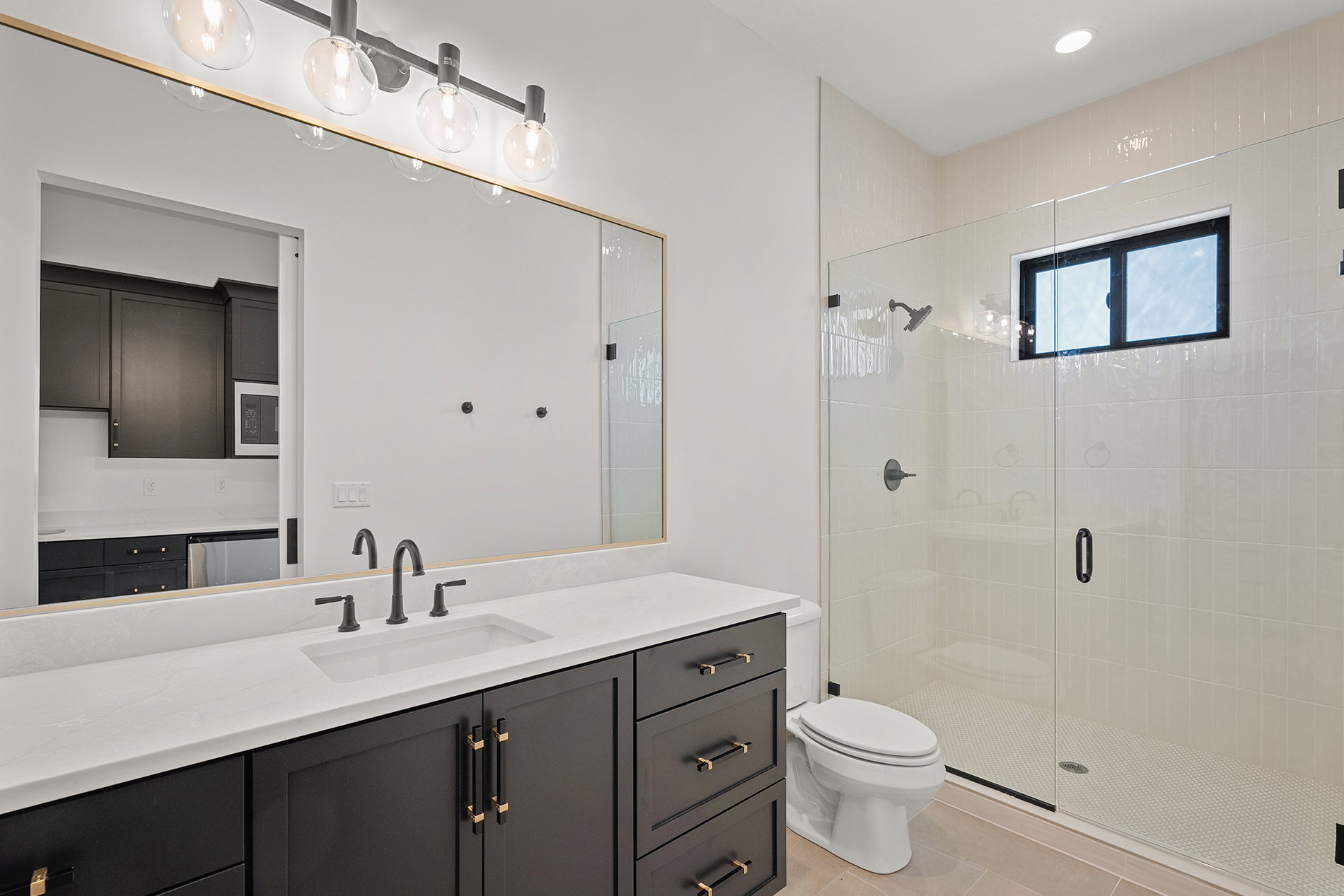 Modern bathroom featuring a dark wood-finish vanity with a white countertop and rectangular undermount sink