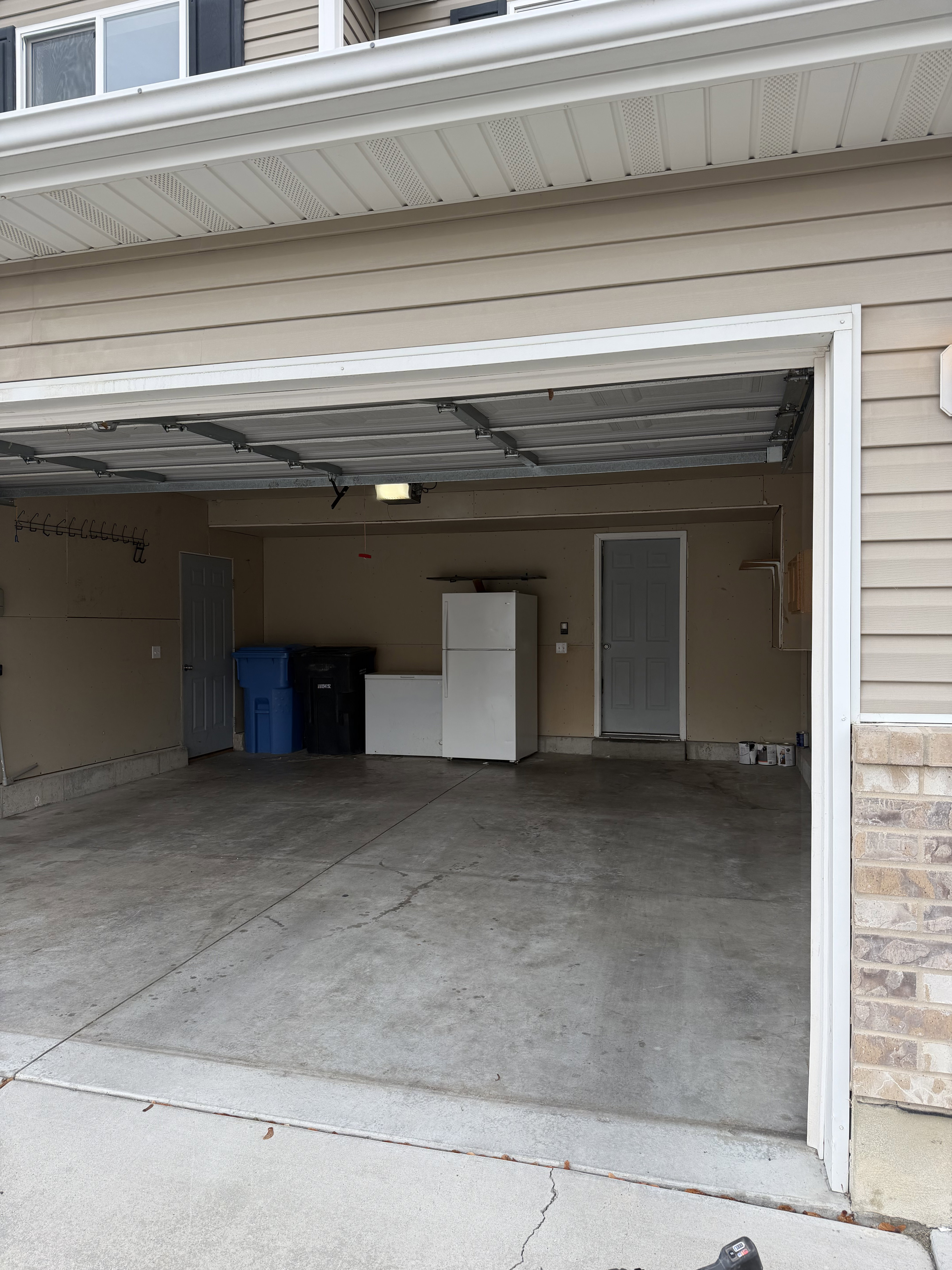Spacious two-car garage with concrete flooring, finished walls, and an overhead light fixture