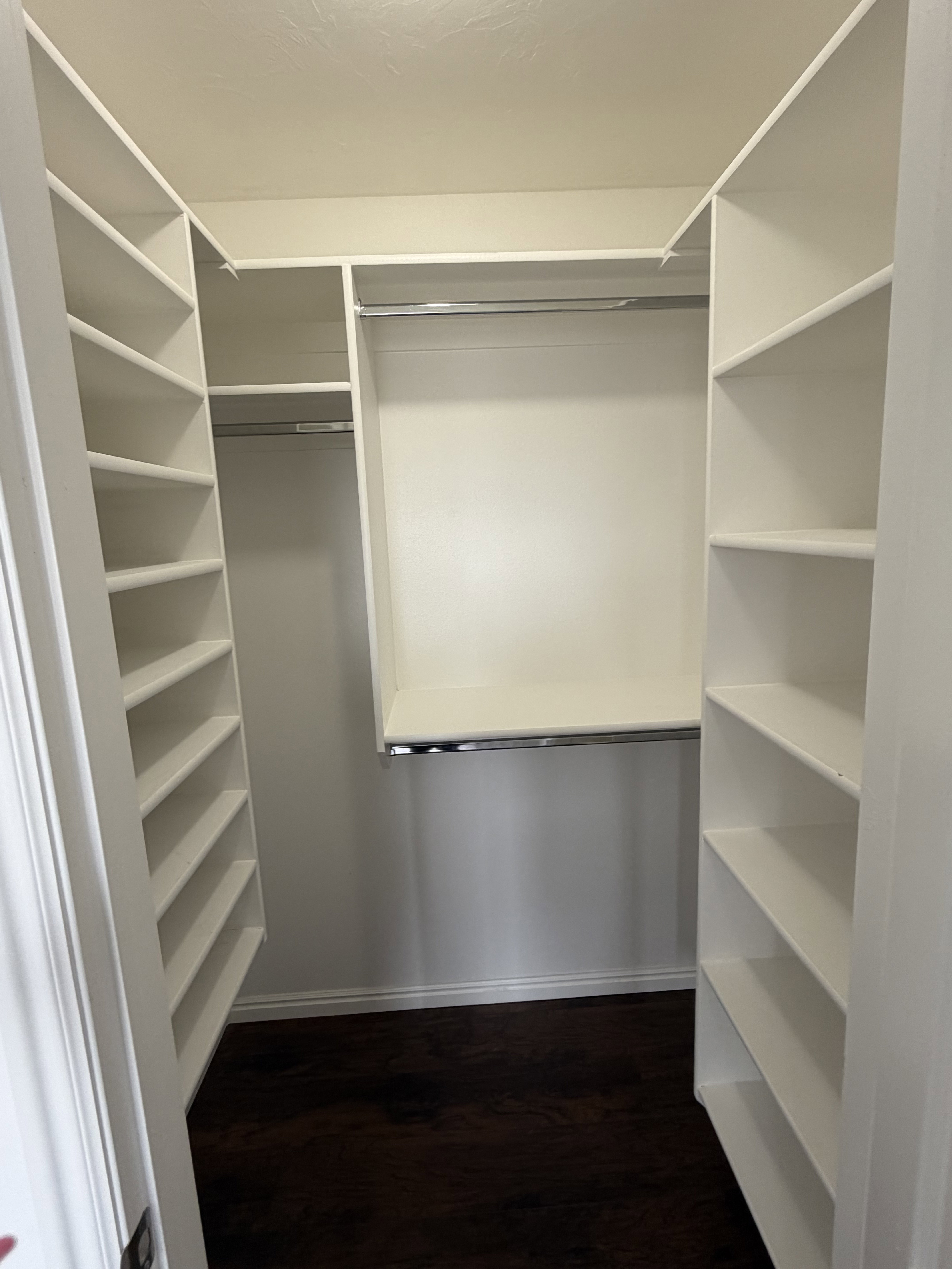 Custom closet system featuring extensive shelving and multiple hanging rods