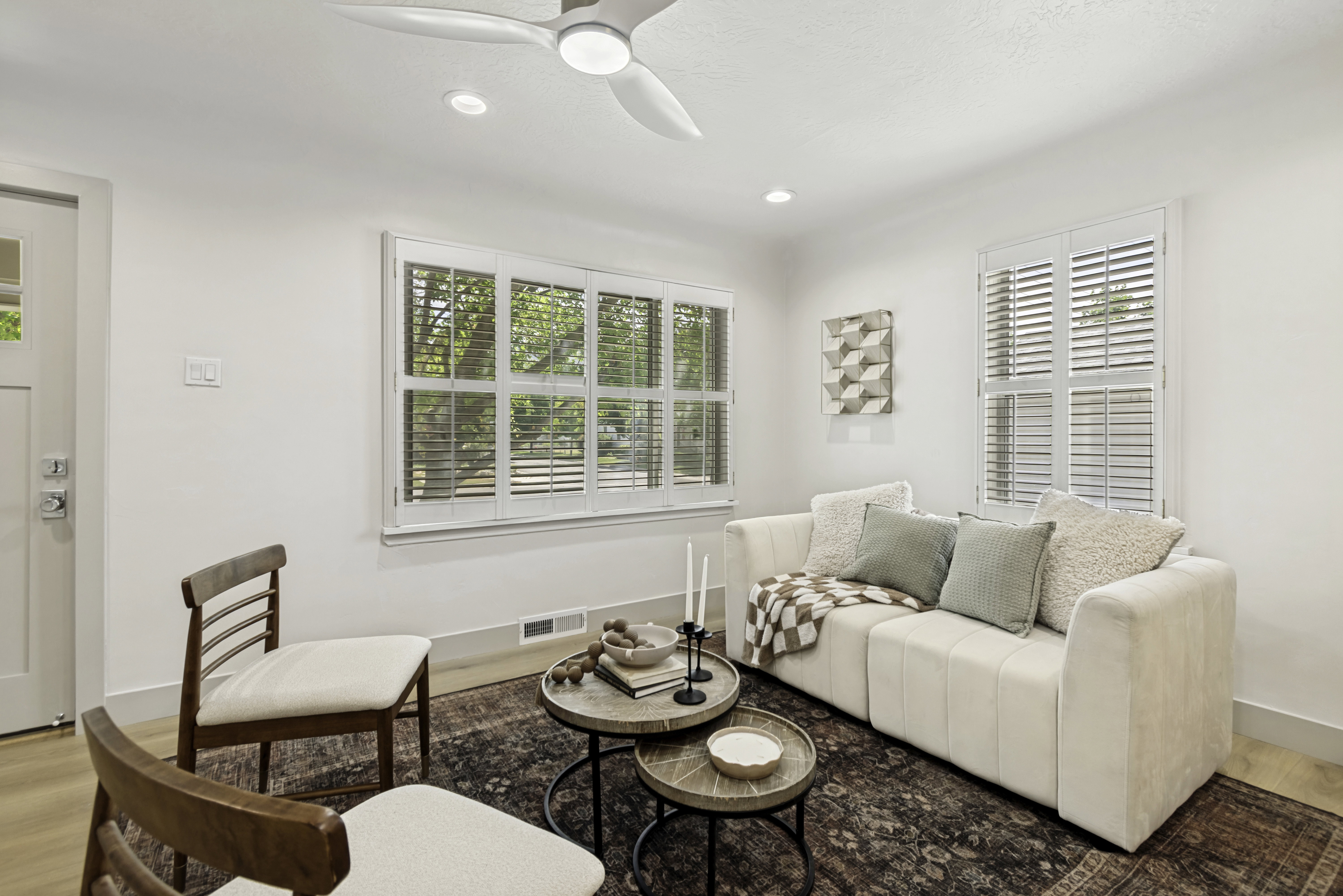 Living area featuring wood-finish flooring, white walls, and a contemporary ceiling fan