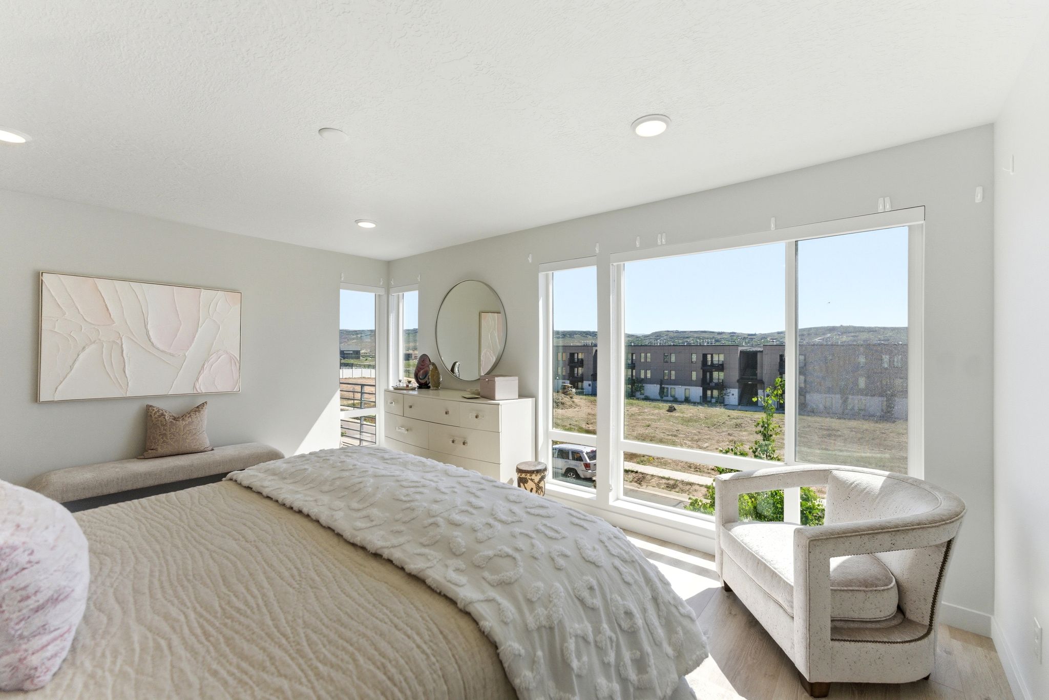 Bedroom featuring large windows, recessed ceiling lighting, light wood-finish flooring, and light-toned walls