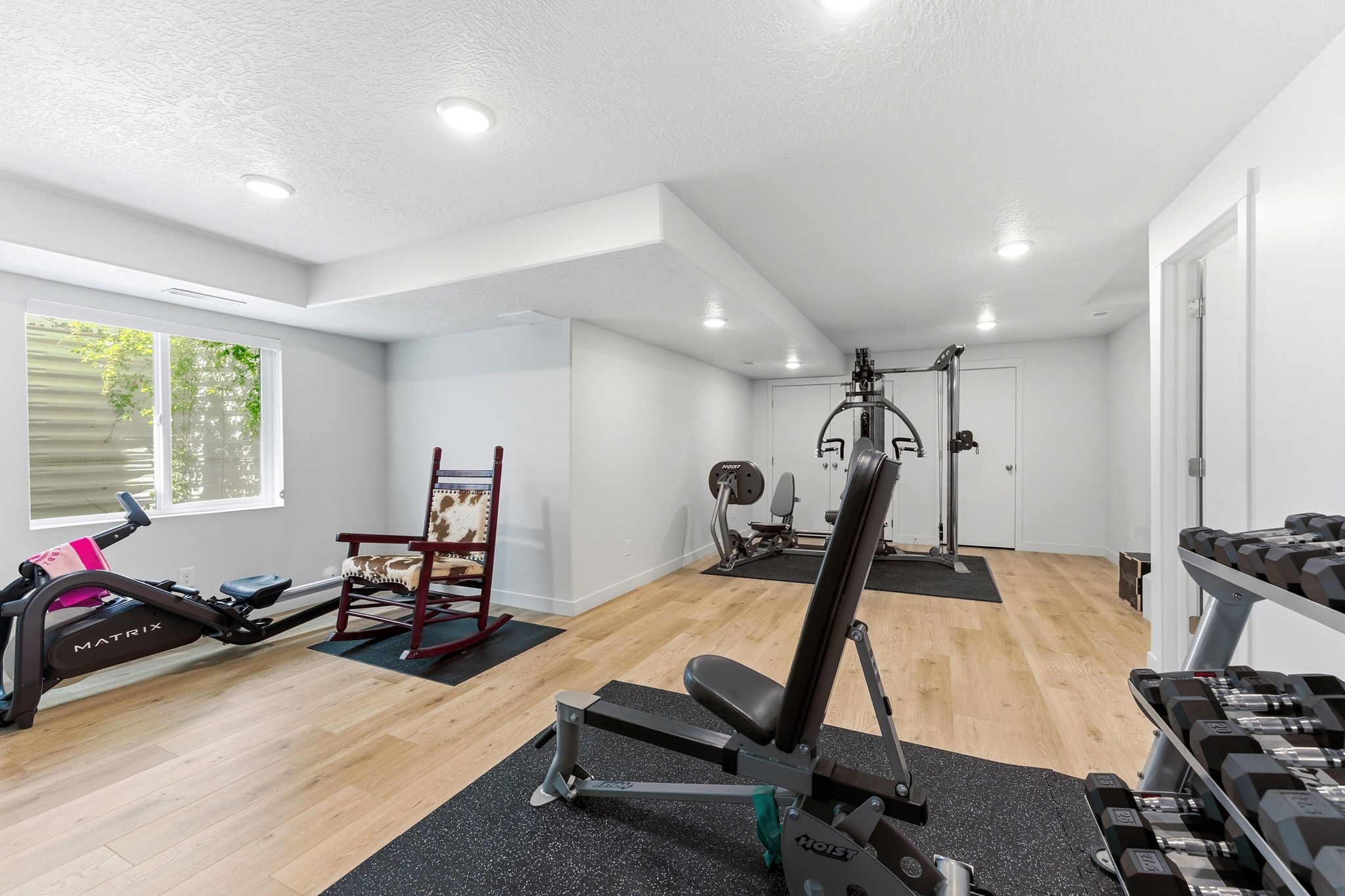 Room featuring recessed lighting, wood-finish flooring, and a large window