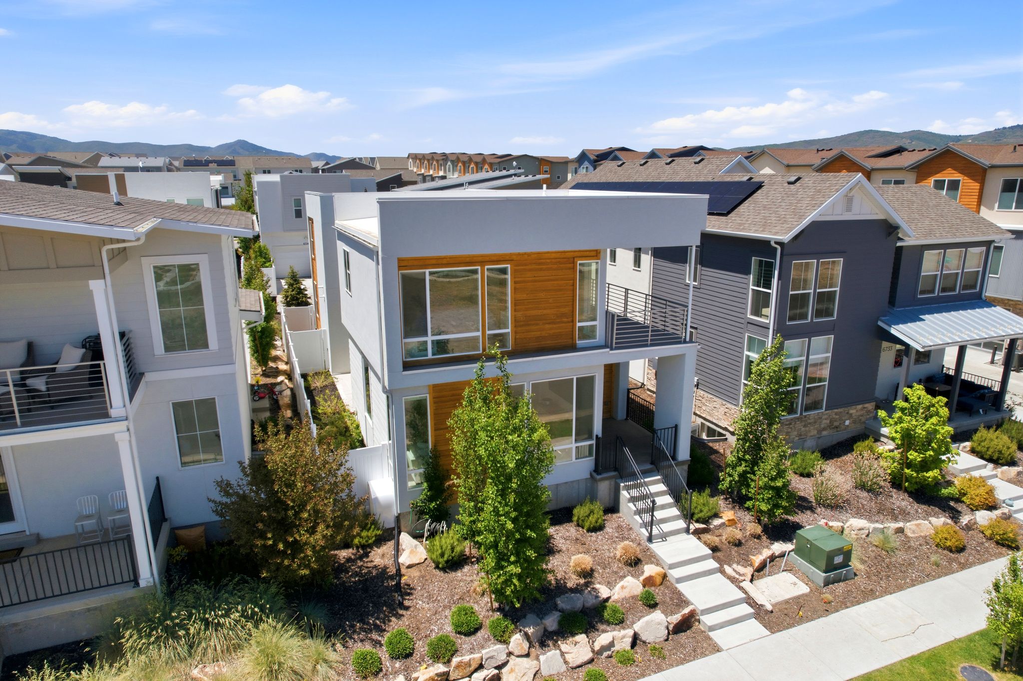 Contemporary multi-story residence featuring a flat roofline and integrated wood-finish paneling
