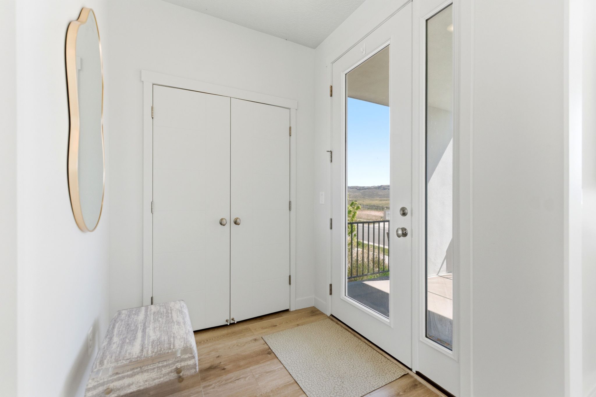 Entryway with double French doors, wood-finish flooring, and a double-door closet