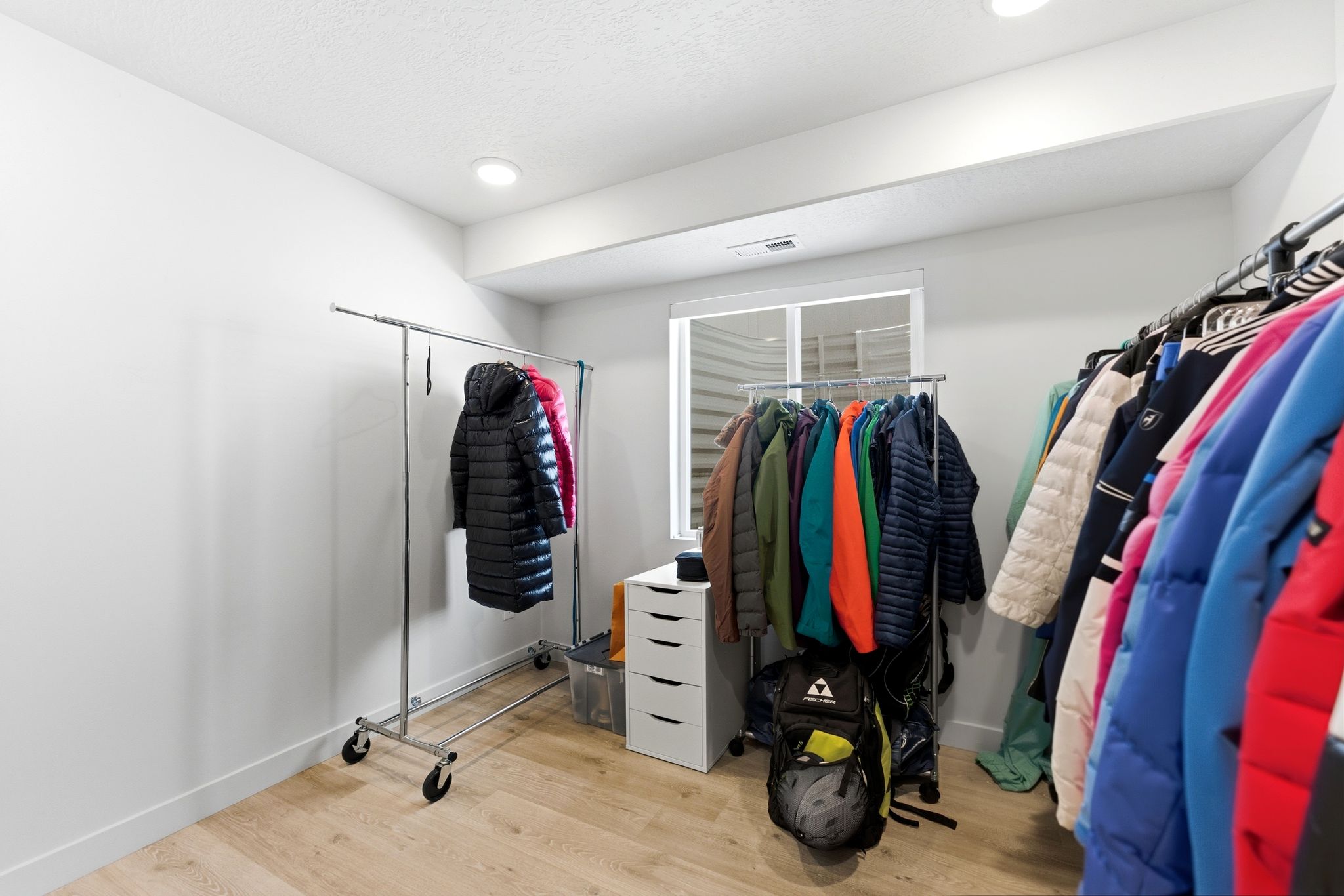 Light wood-finish flooring, white walls, and a recessed ceiling light create a bright interior