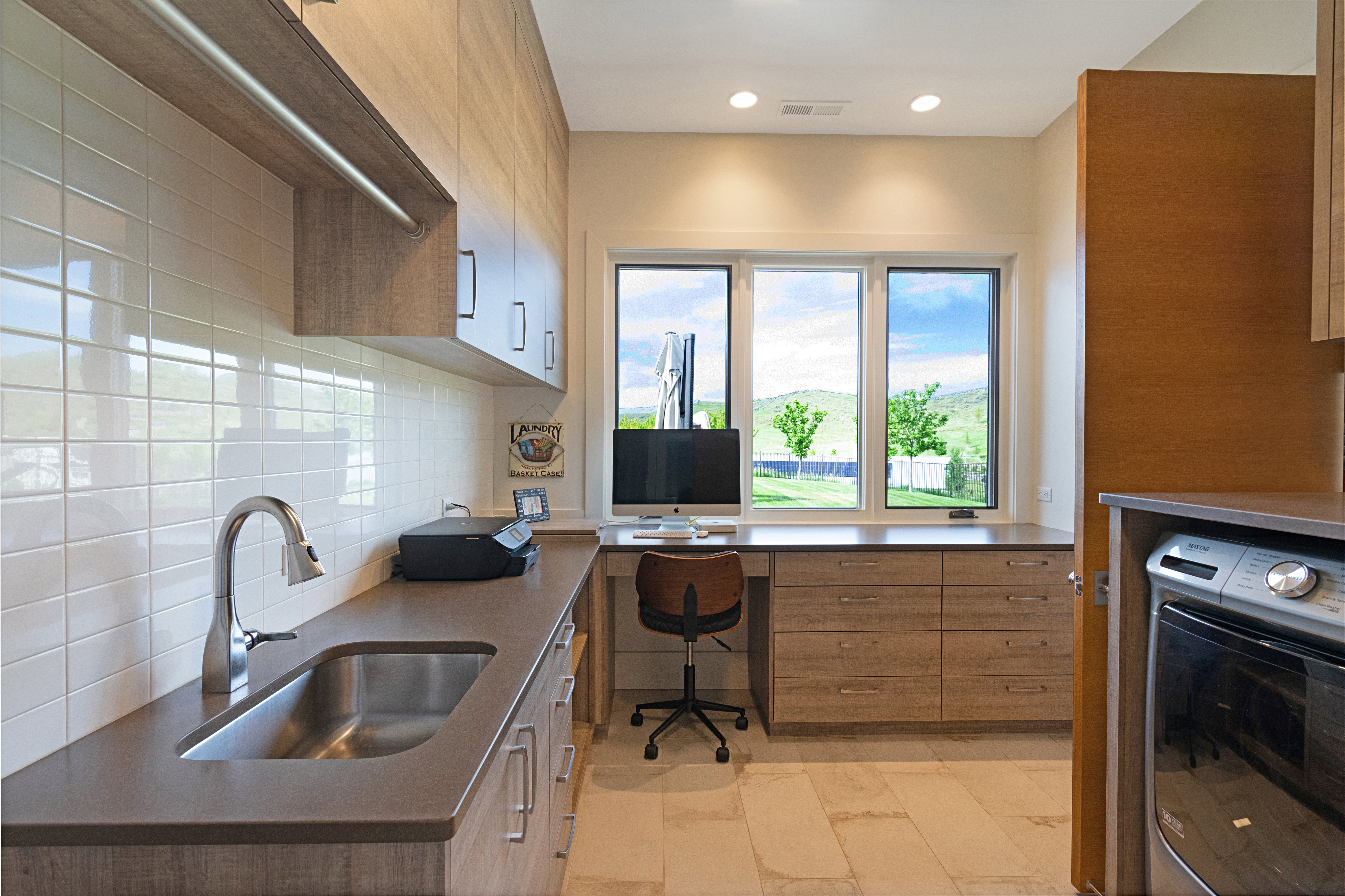 Dedicated work-from-home area featuring expansive windows, integrated cabinetry, a built-in countertop, and a stainless steel sink with a gooseneck faucet