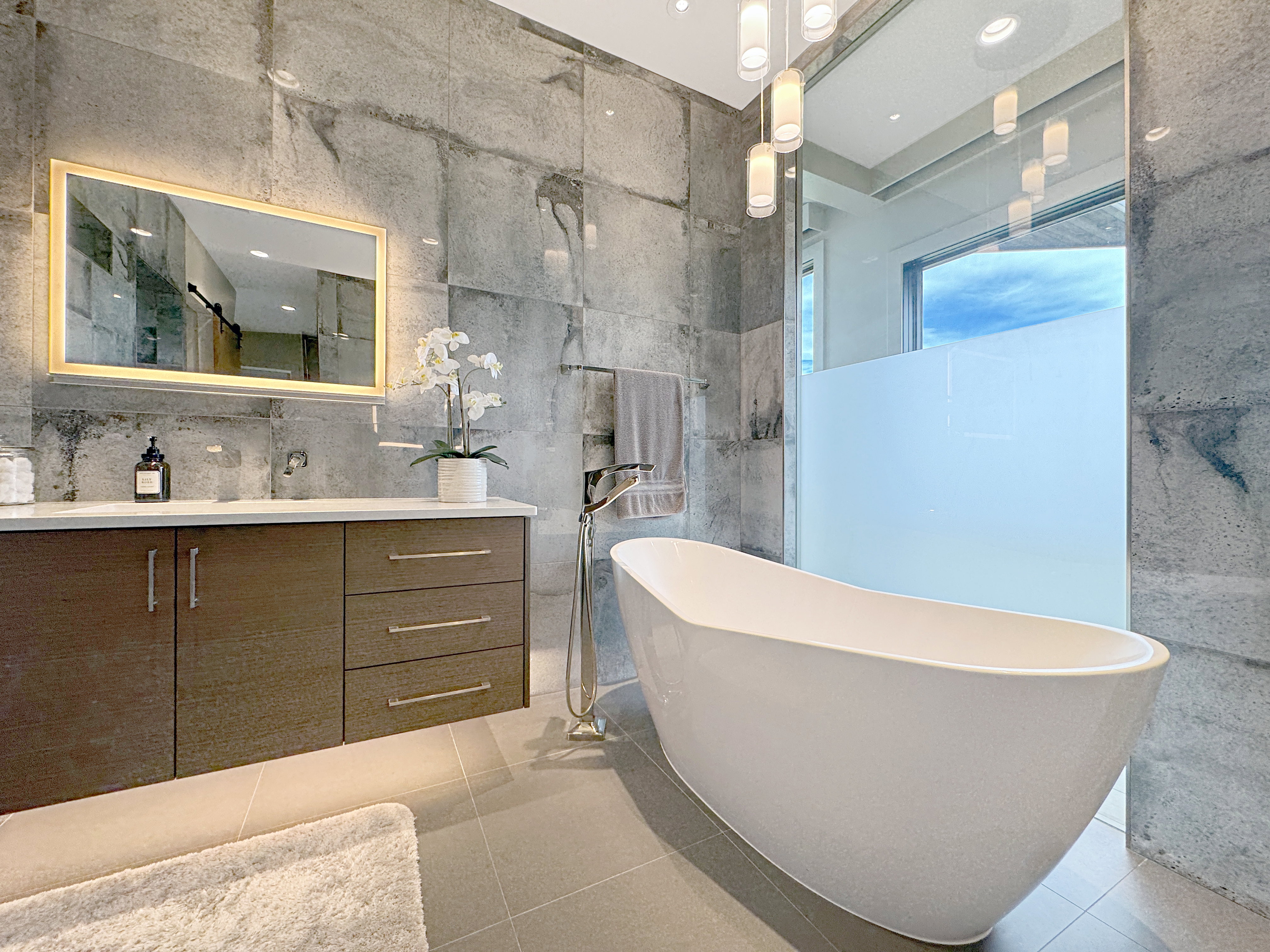 Contemporary bathroom featuring a freestanding soaking tub with a floor-mounted gold-tone faucet