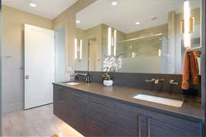 Floating vanity with integrated dual sinks and a dark countertop, complemented by modern wall-mounted faucets