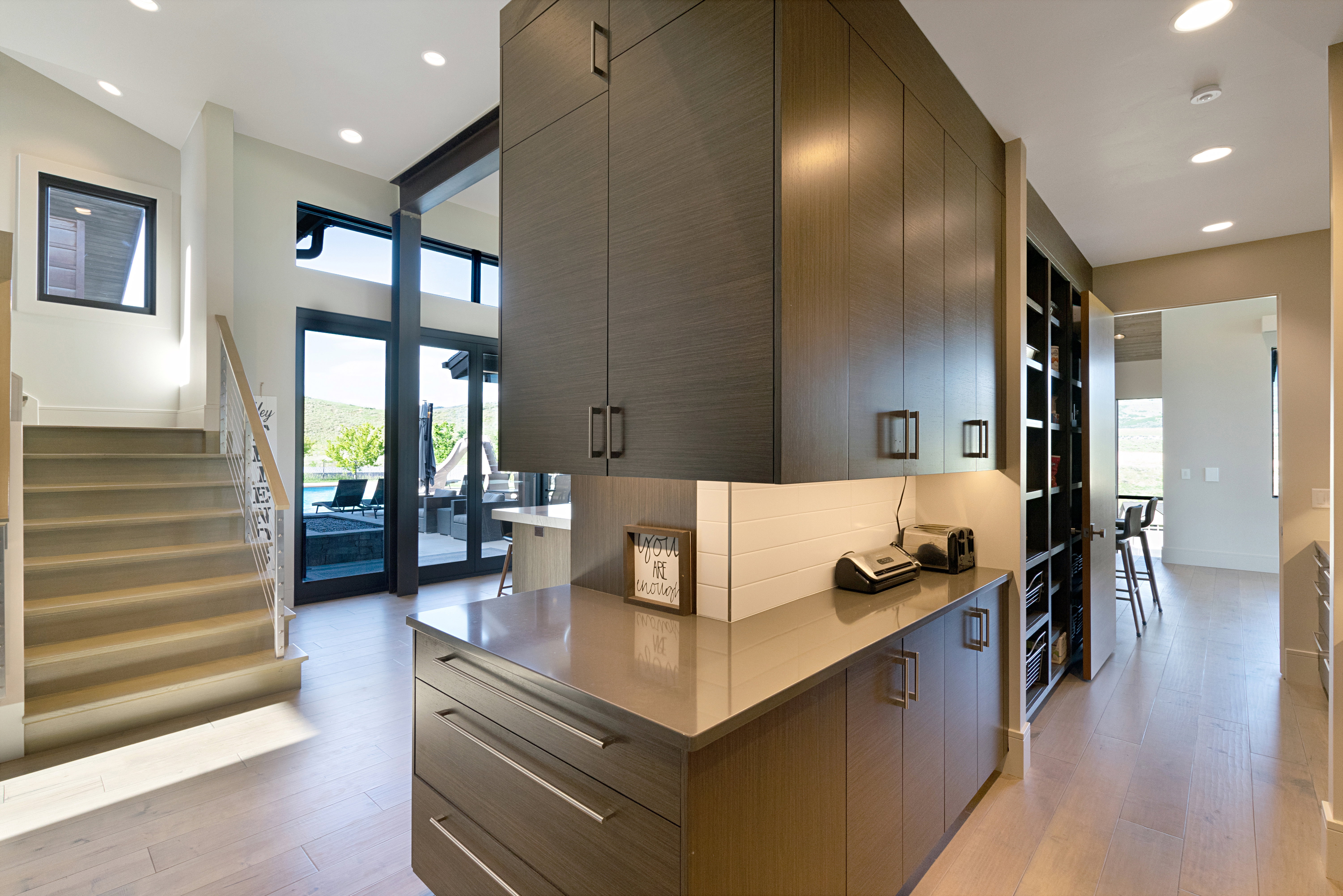 Modern built-in cabinetry with ample storage, featuring contemporary hardware and a light-toned countertop