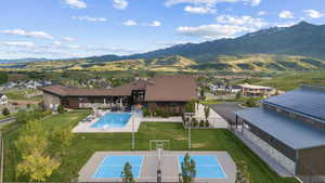 Expansive property featuring a large swimming pool with a diving board, a separate sport court, and a contemporary multi-level residence with extensive outdoor patio space