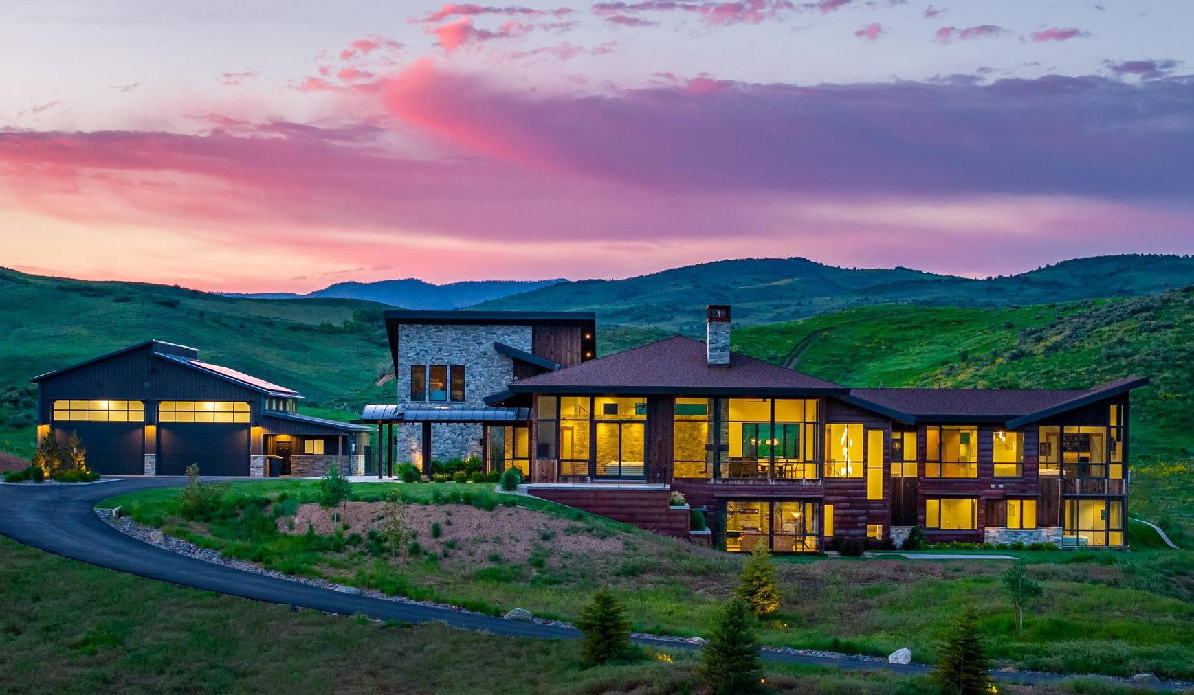 Modern architectural design featuring extensive window walls, stone accents, and wood siding