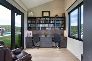 Dedicated office space featuring built-in shelving, two workstations, and ample natural light