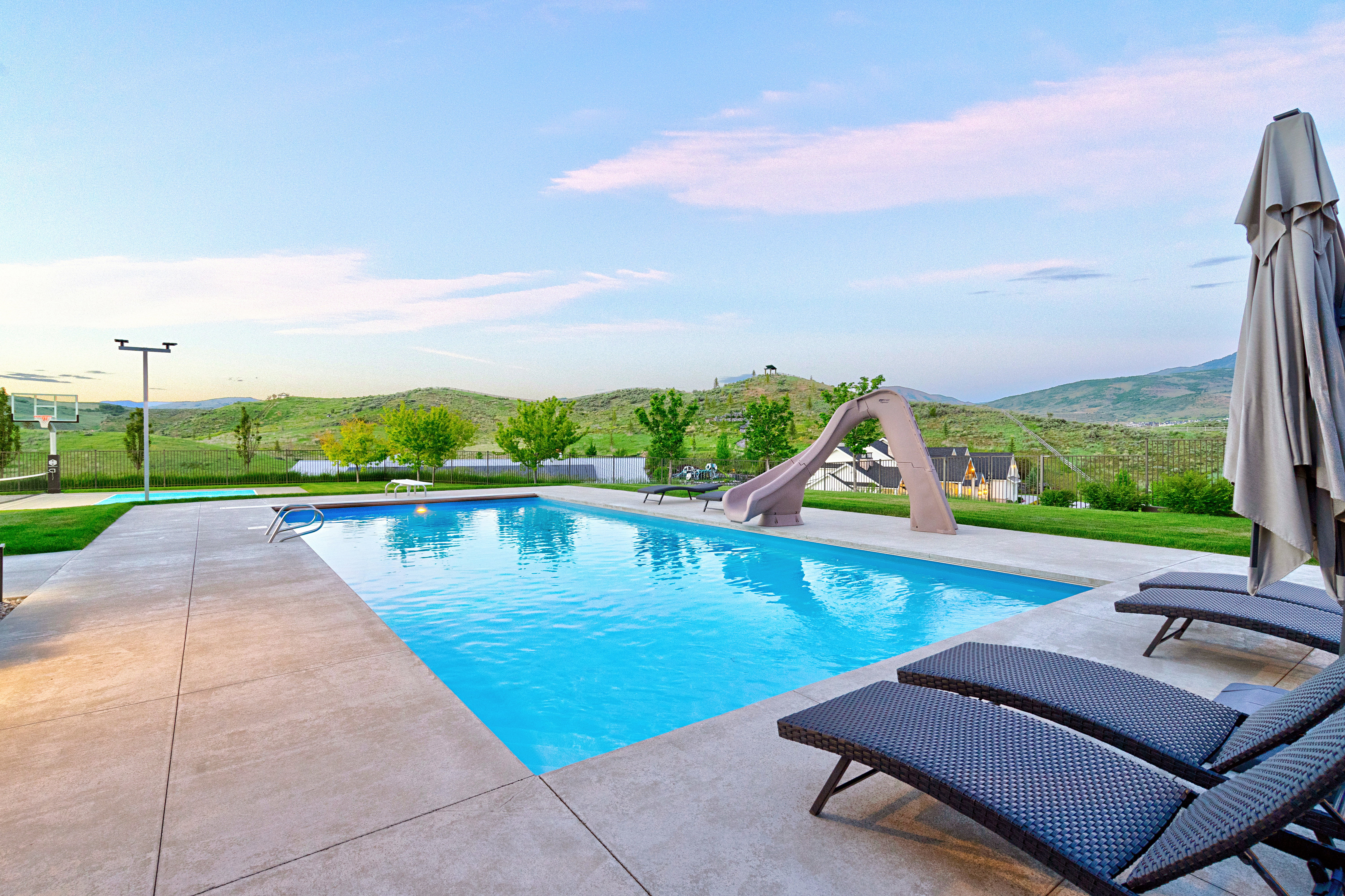 Rectangular swimming pool with a concrete surround and a built-in water slide