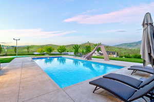 Rectangular swimming pool with a concrete surround and a built-in water slide