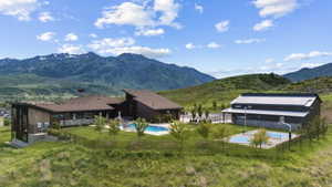 Architectural complex featuring a swimming pool, multiple sports courts, and mountain scenery