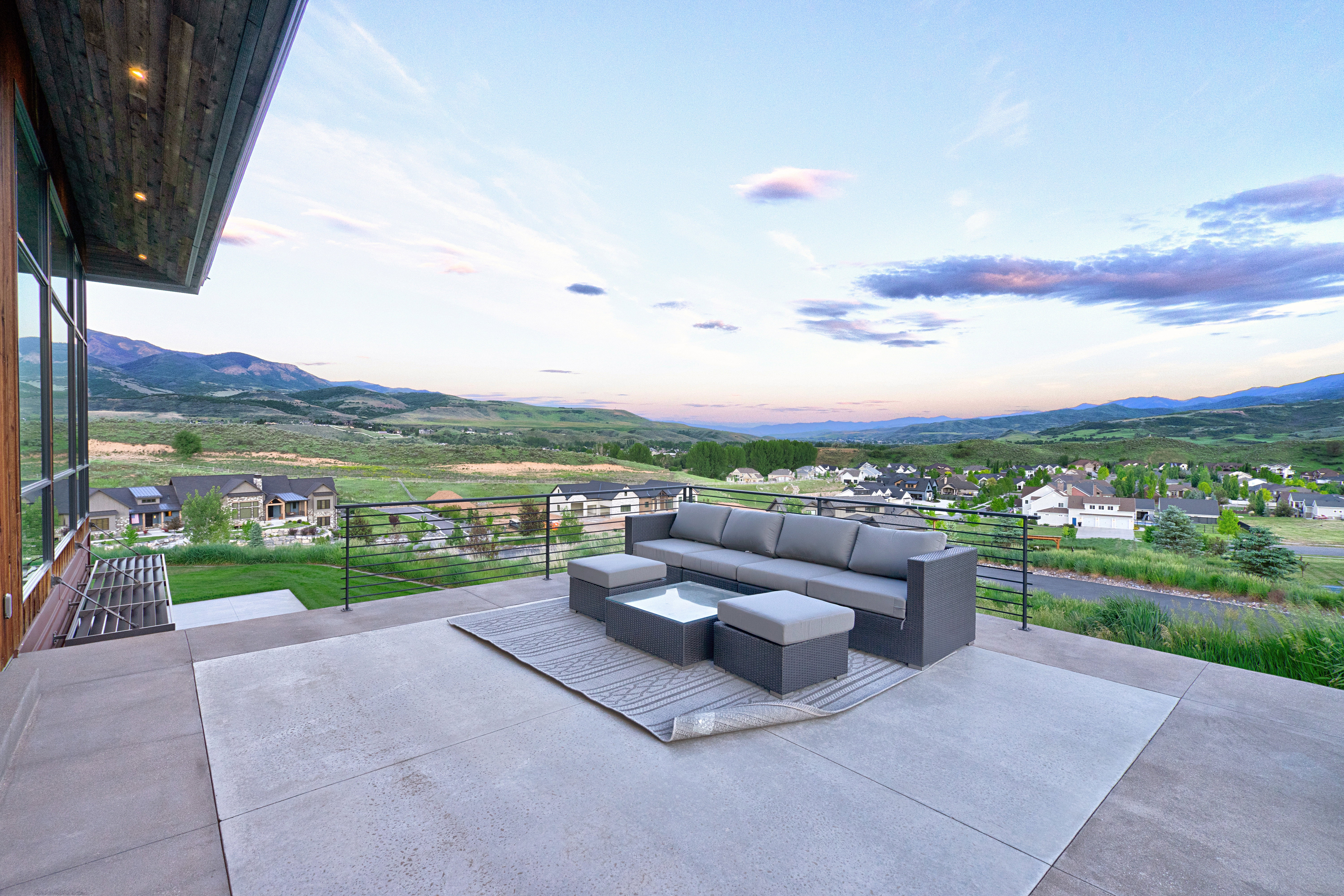 Spacious concrete patio with surrounding mountain range and distant residential properties