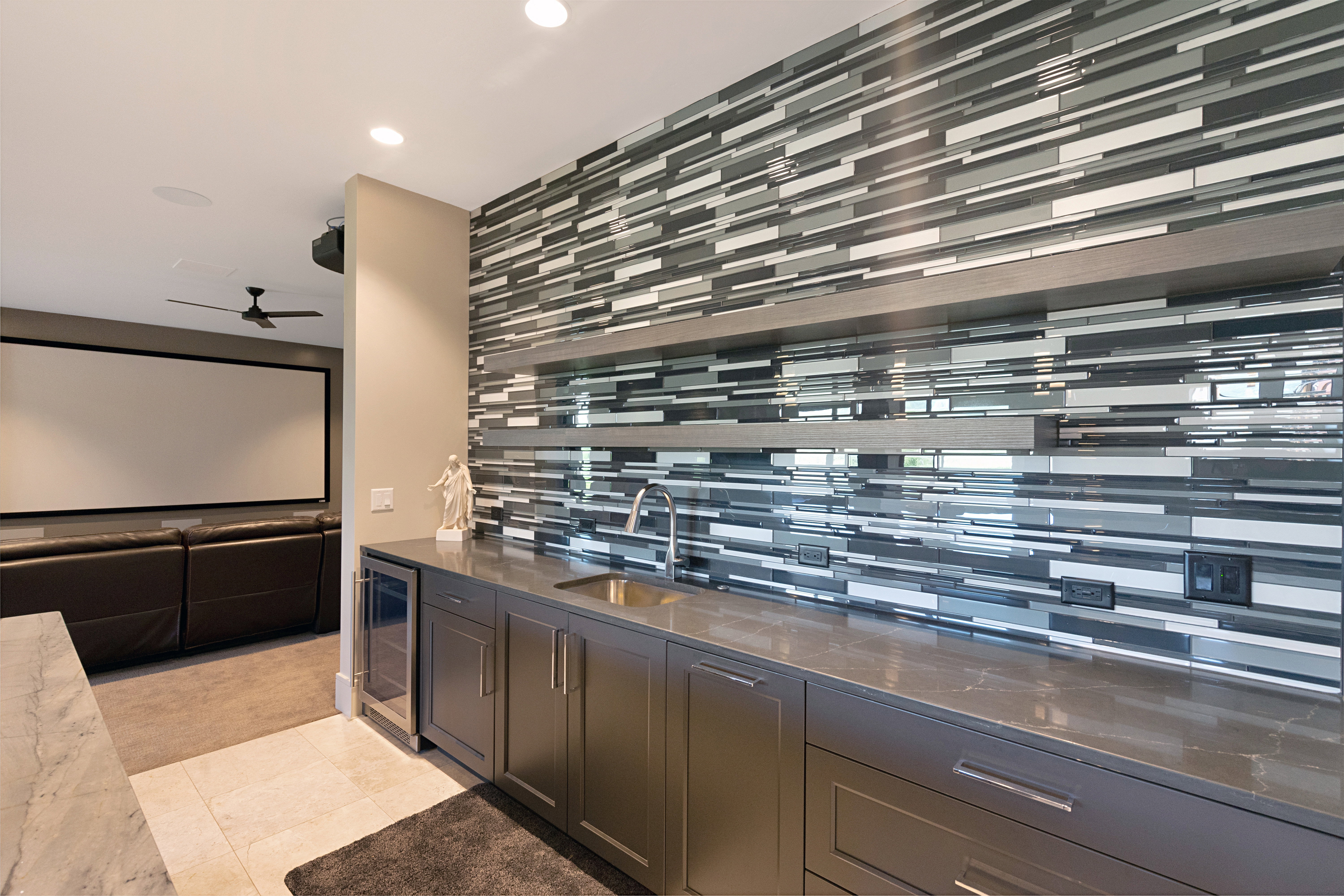 Wet bar with a mosaic tile accent wall, integrated beverage cooler, and undermount sink