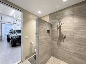 Walk-in shower with large format tile walls and a built-in niche
