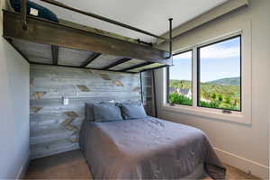 Custom-built loft bed with industrial-style metal framing and a wood-panel accent wall