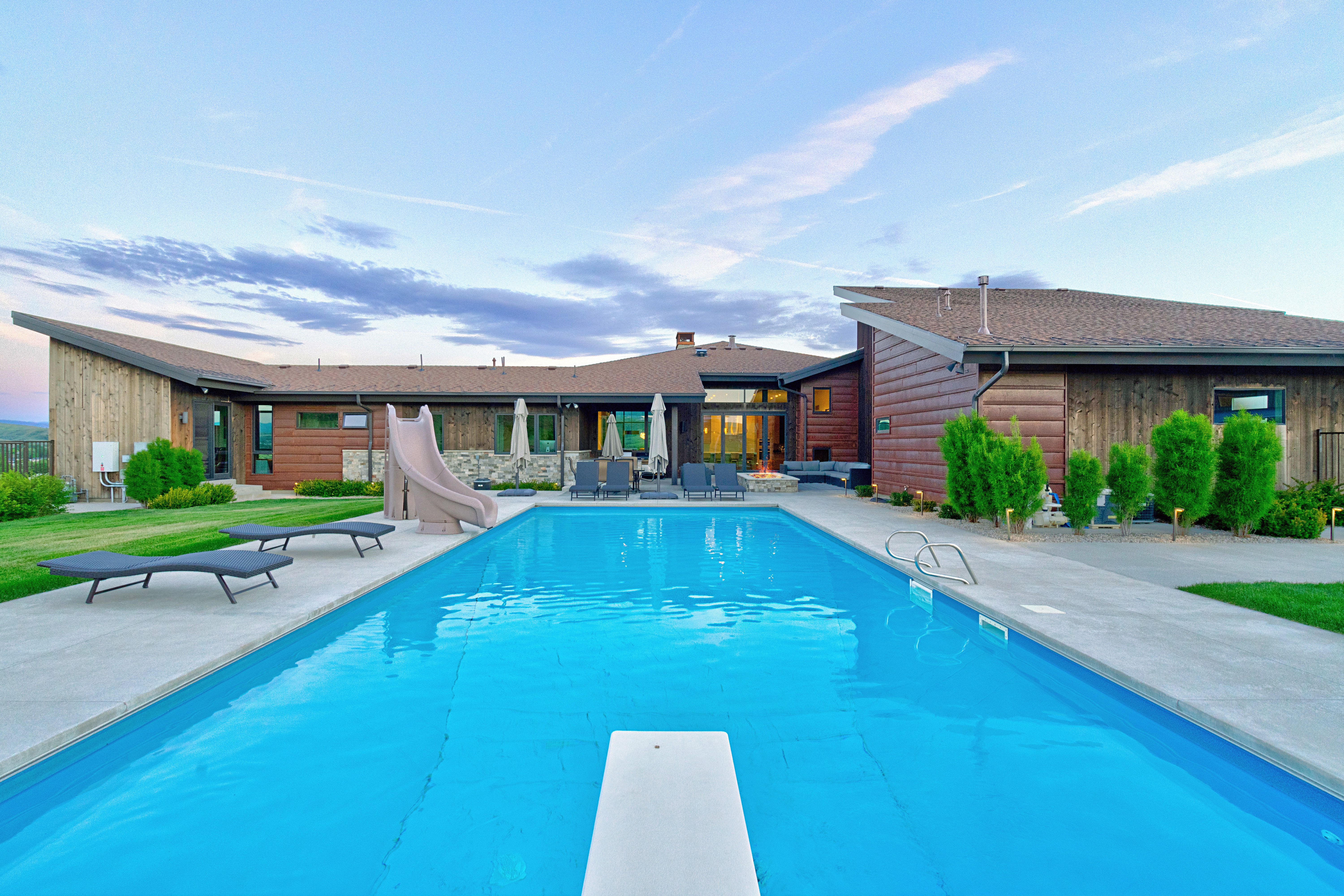 Expansive outdoor pool with a diving board and concrete surround