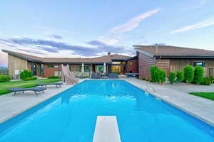 Expansive outdoor pool with a diving board and concrete surround