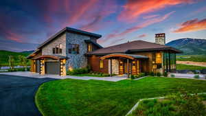 Modern contemporary exterior with stone and wood siding, a multi-paneled garage door, and a stone chimney
