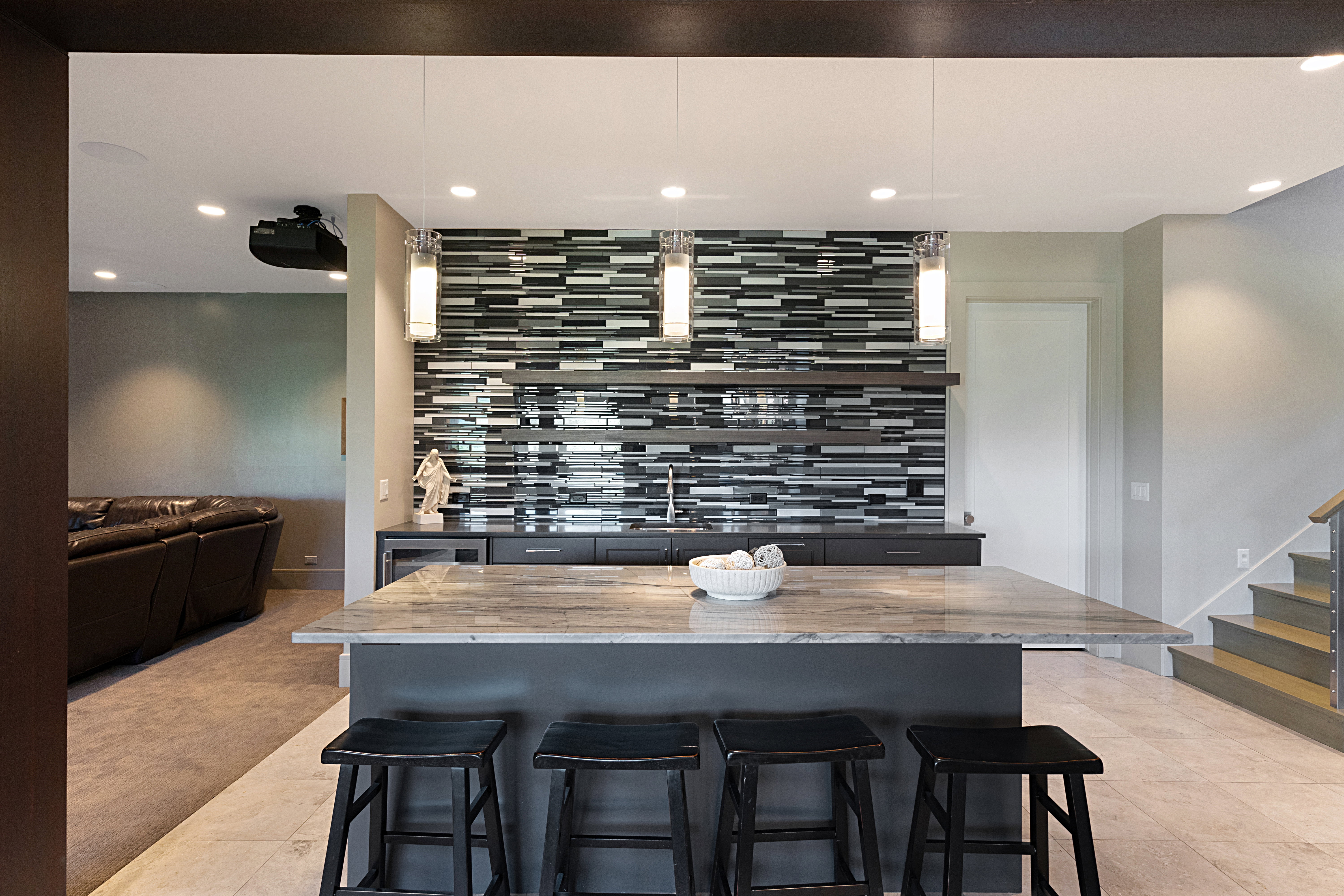 Entertainment area featuring a central island with a stone countertop and seating for three