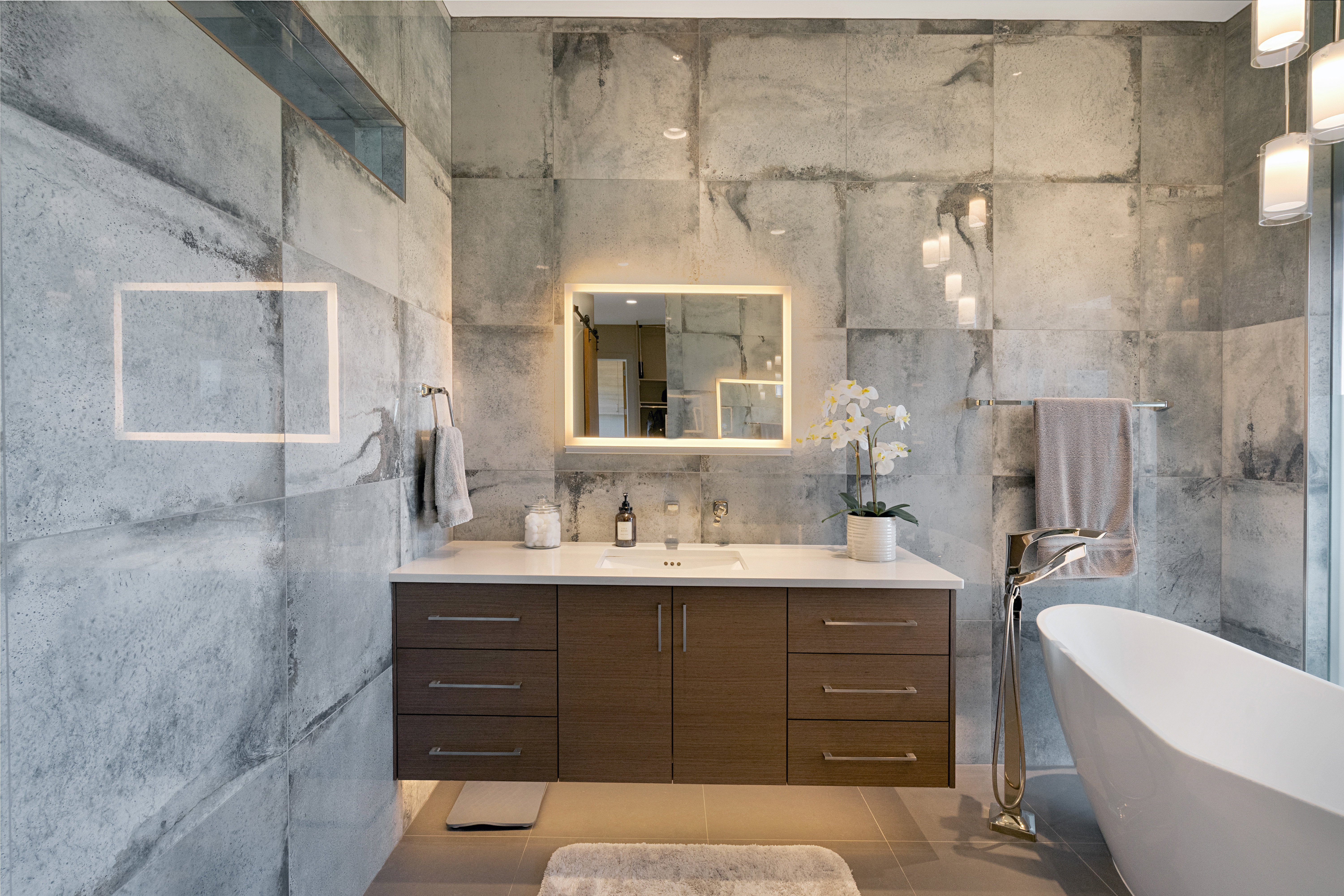 Modern bathroom featuring a floating wood-finish vanity with a white countertop and rectangular sink
