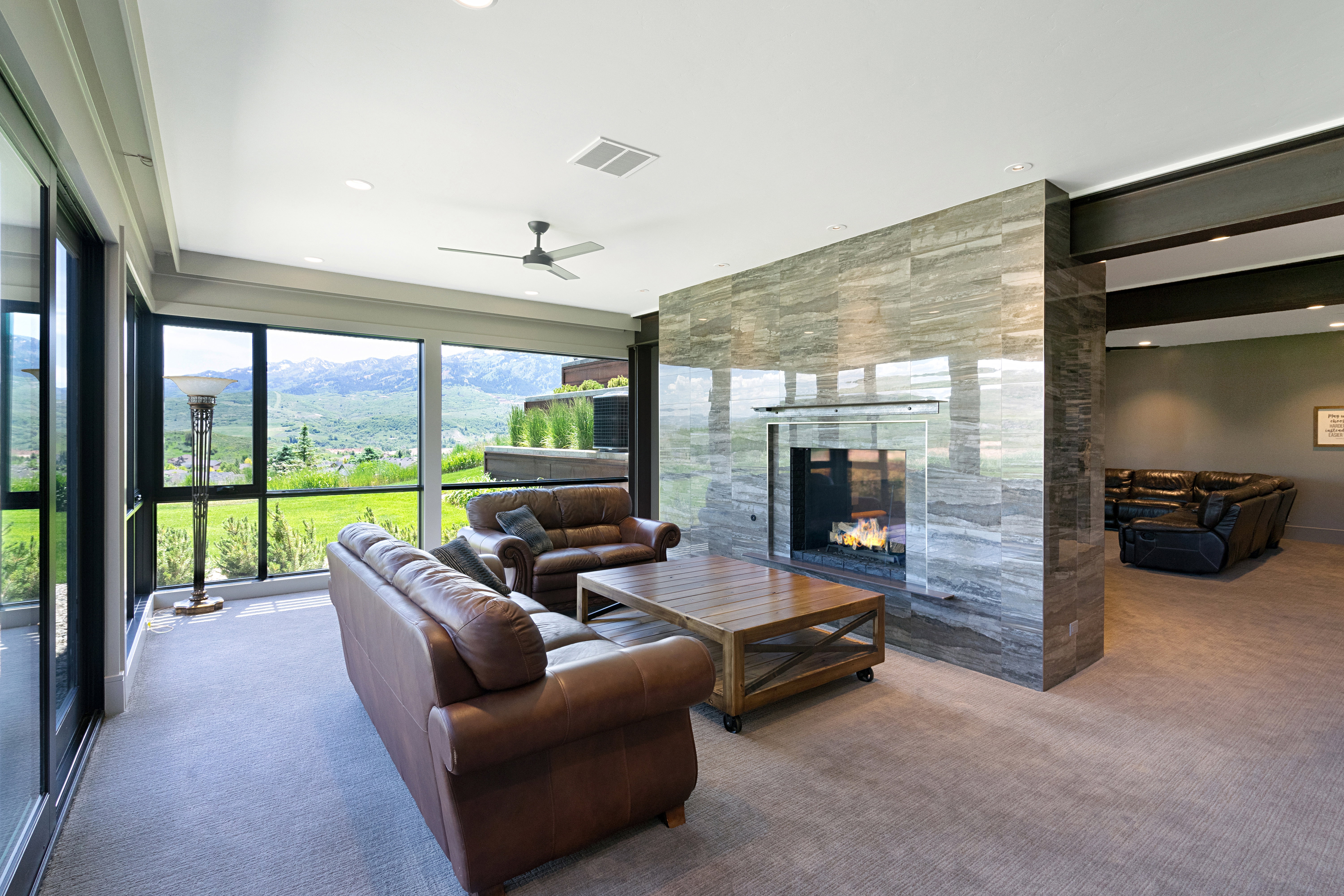 Living space featuring a stone-clad fireplace and expansive windows