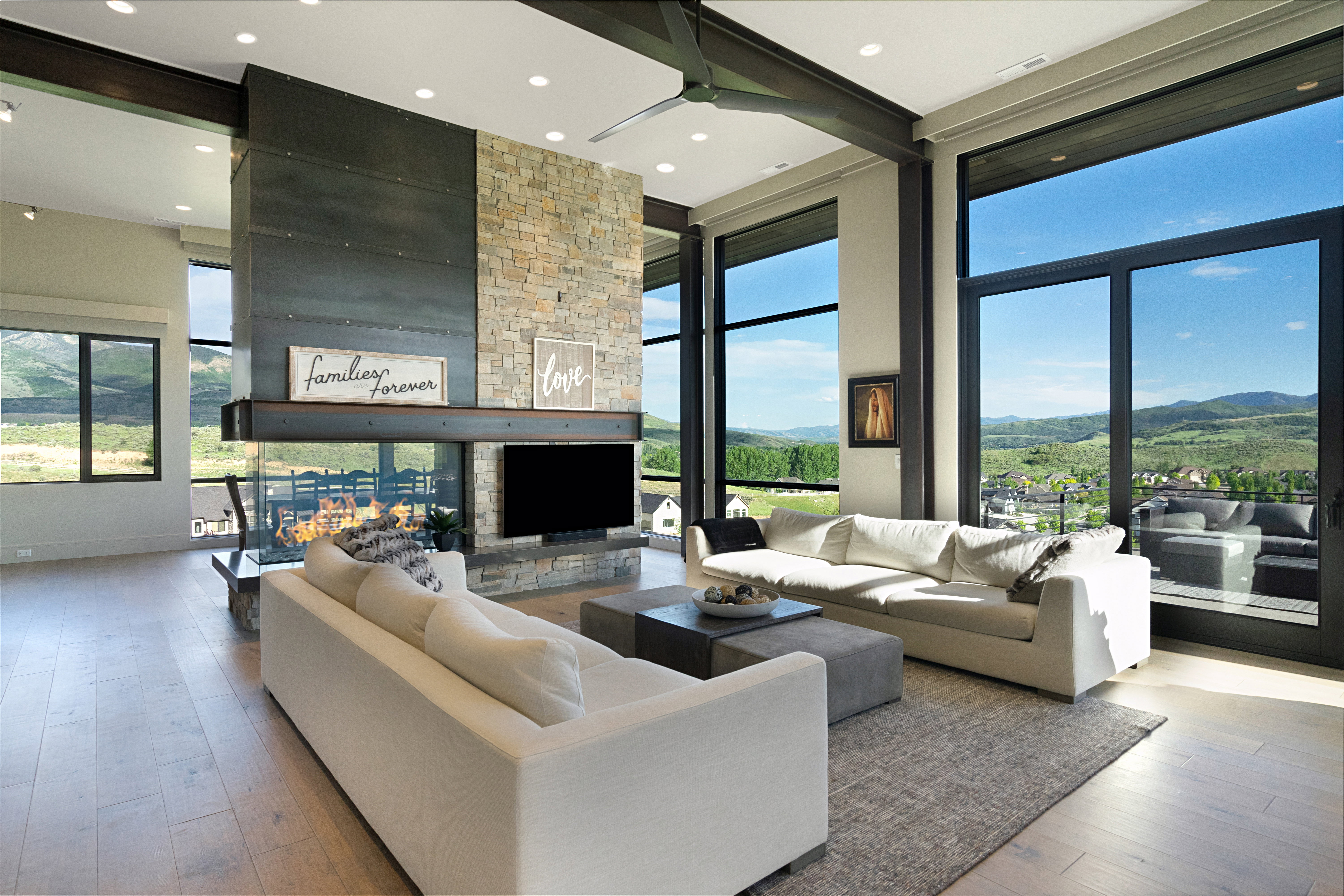 Great room with high ceilings, featuring exposed structural beams and recessed lighting