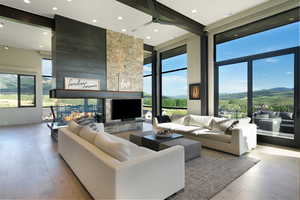 Great room with high ceilings, featuring exposed structural beams and recessed lighting
