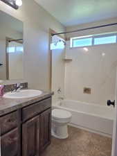Bathroom featuring a vanity with dark wood-finish cabinetry, a white basin sink, and a speckled countertop