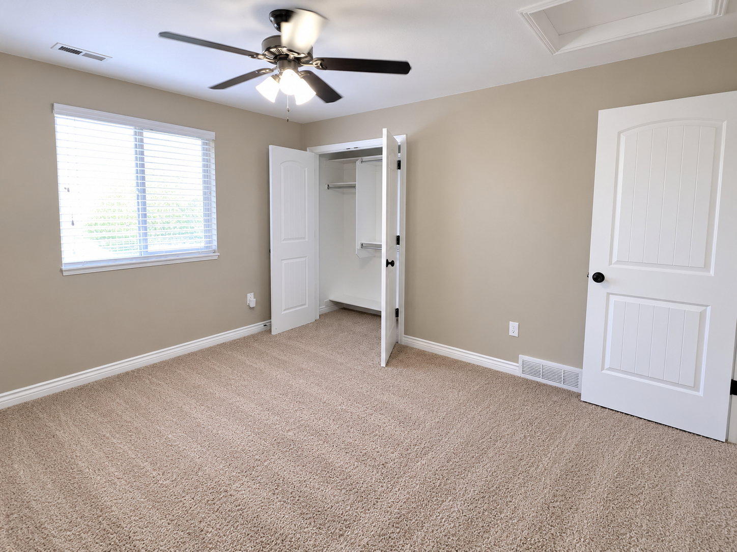 Neutral-toned walls complement the textured carpeting