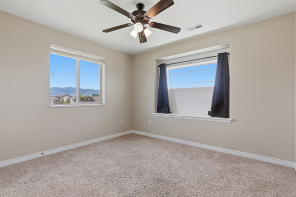 Carpeted interior space featuring neutral wall tones and crown molding