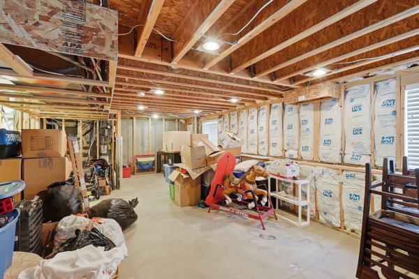 Unfinished basement space featuring exposed wood framing, concrete flooring, recessed lighting, and wall insulation