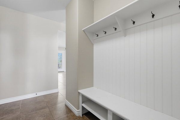Entryway featuring a built-in white bench with storage cubbies and a beadboard accent wall with integrated coat hooks