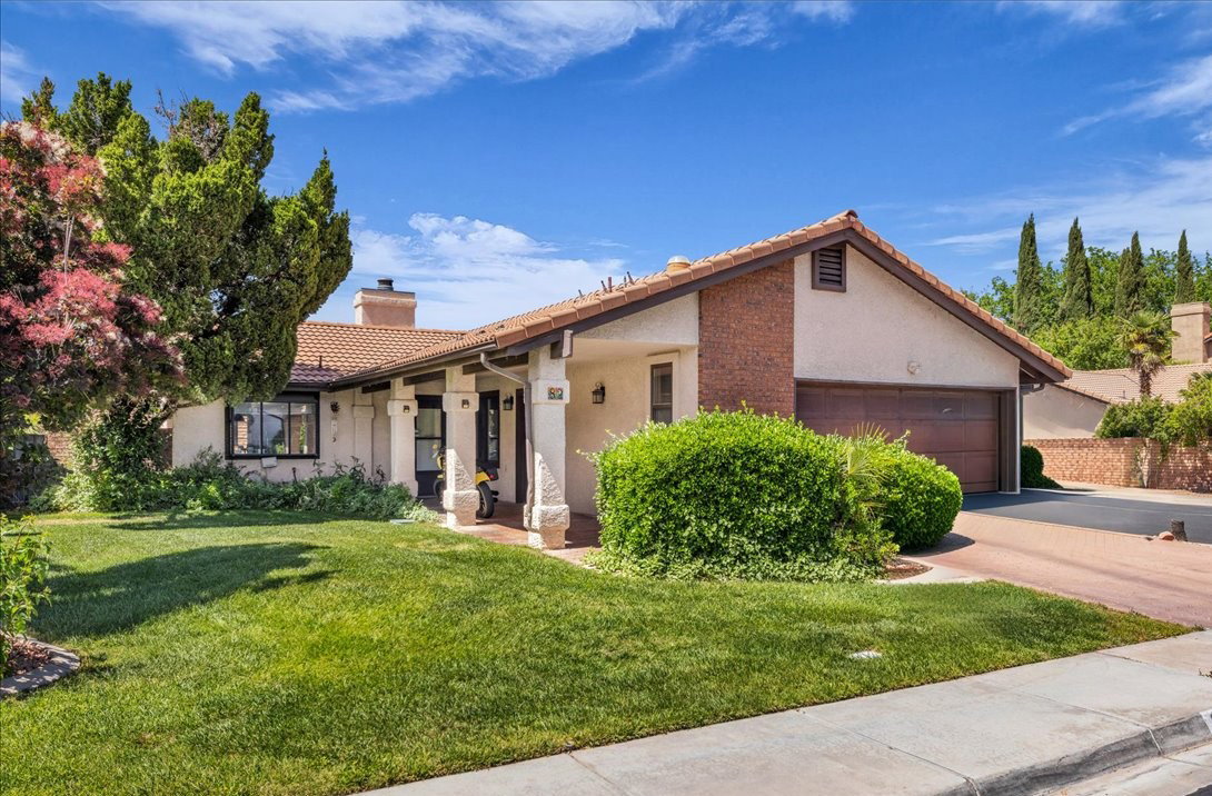 Stucco exterior with brick accents, a terracotta tile roof, and a covered entryway