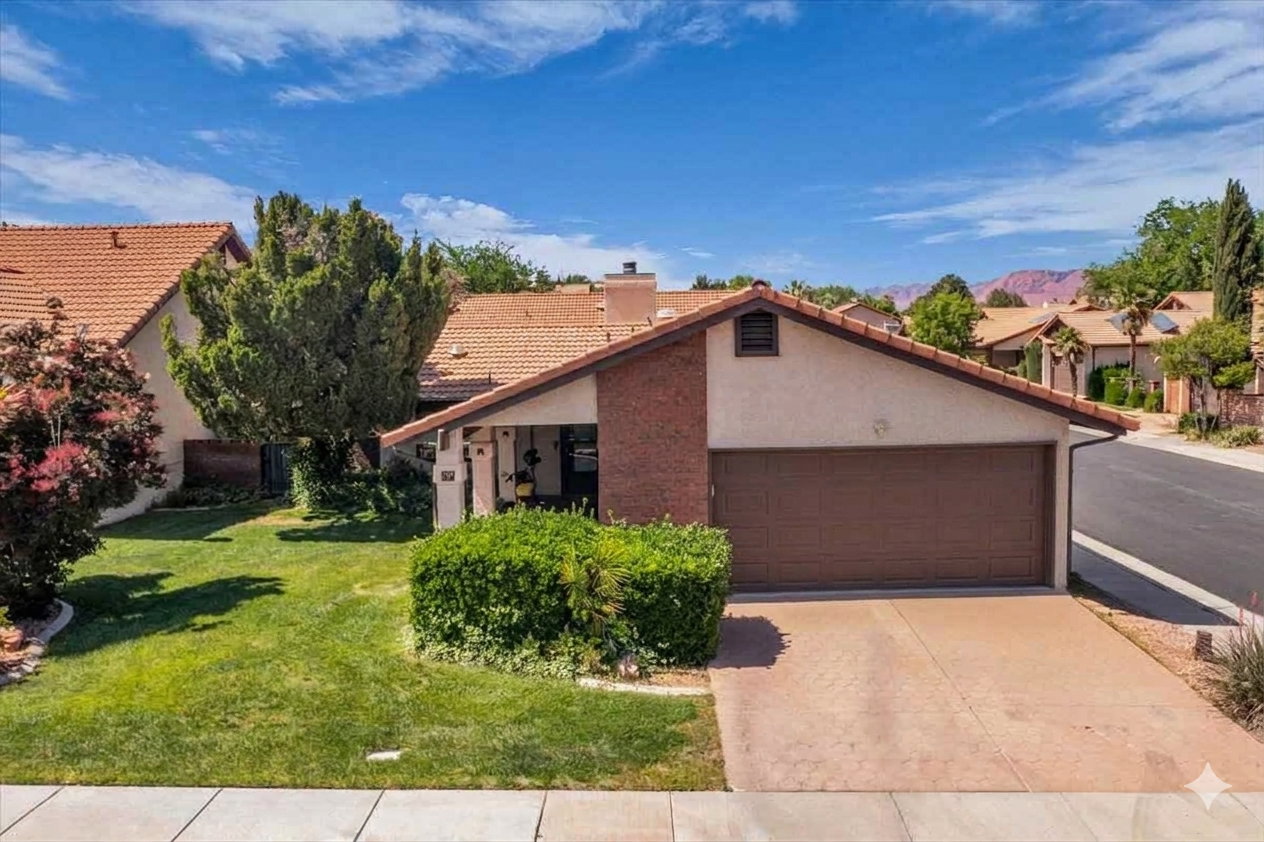 Single-story residence featuring a tile roof, an integrated garage with a brown door, and a brick facade accent
