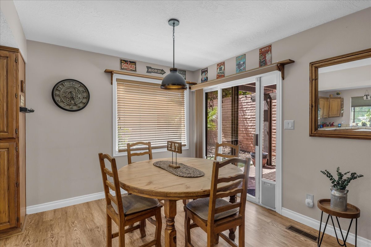 Dining area featuring wood-finish flooring, a contemporary pendant light fixture, and 3-toned paint