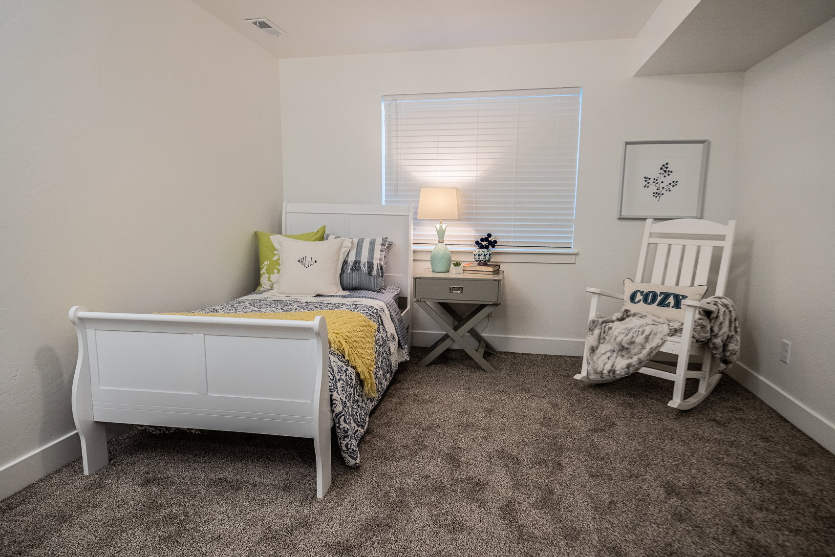 Room featuring a single window with blinds, light neutral wall tones, and dark gray carpeting