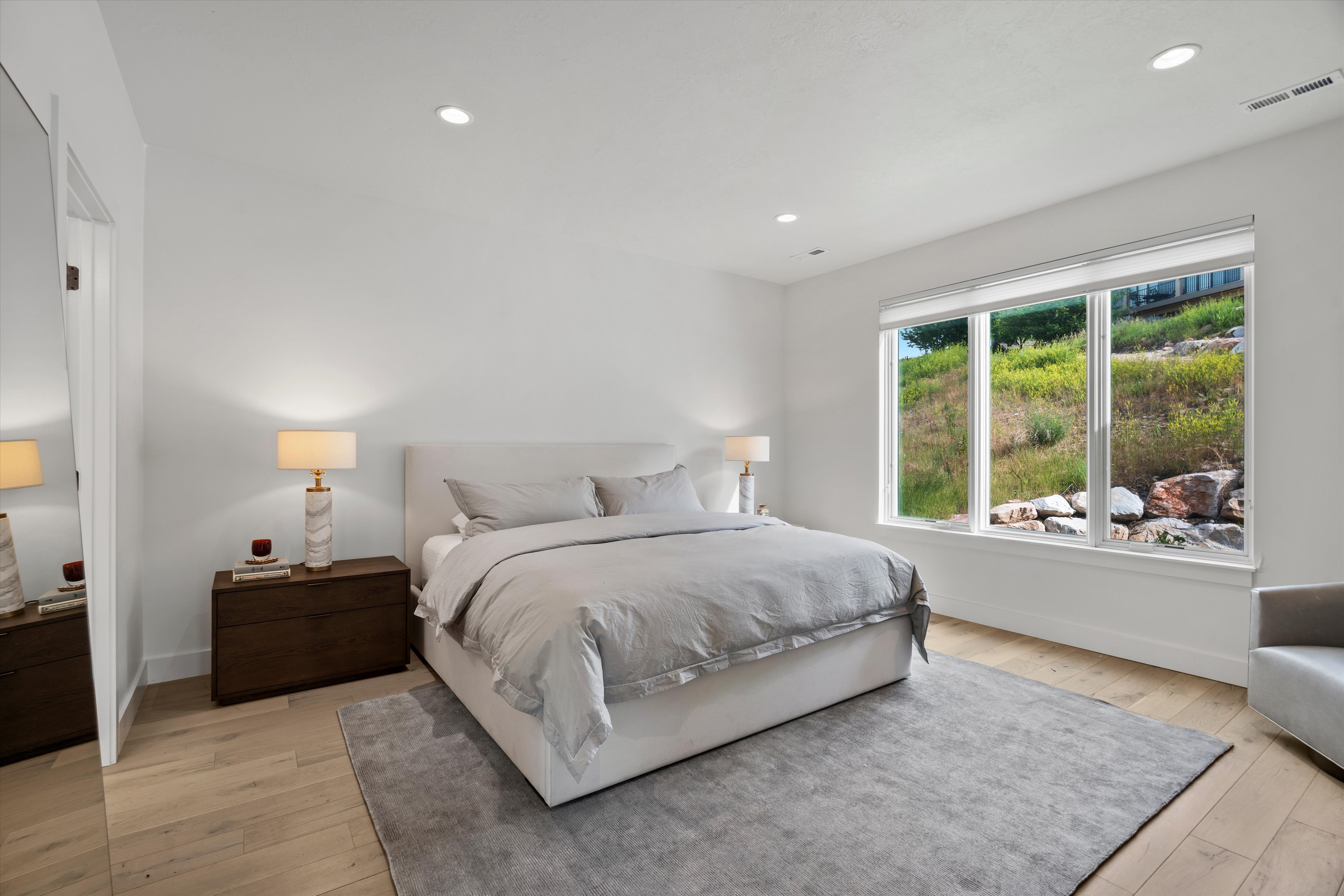 Oversized primary suite with large picture window, en-suite bath, and large walk-in closet.